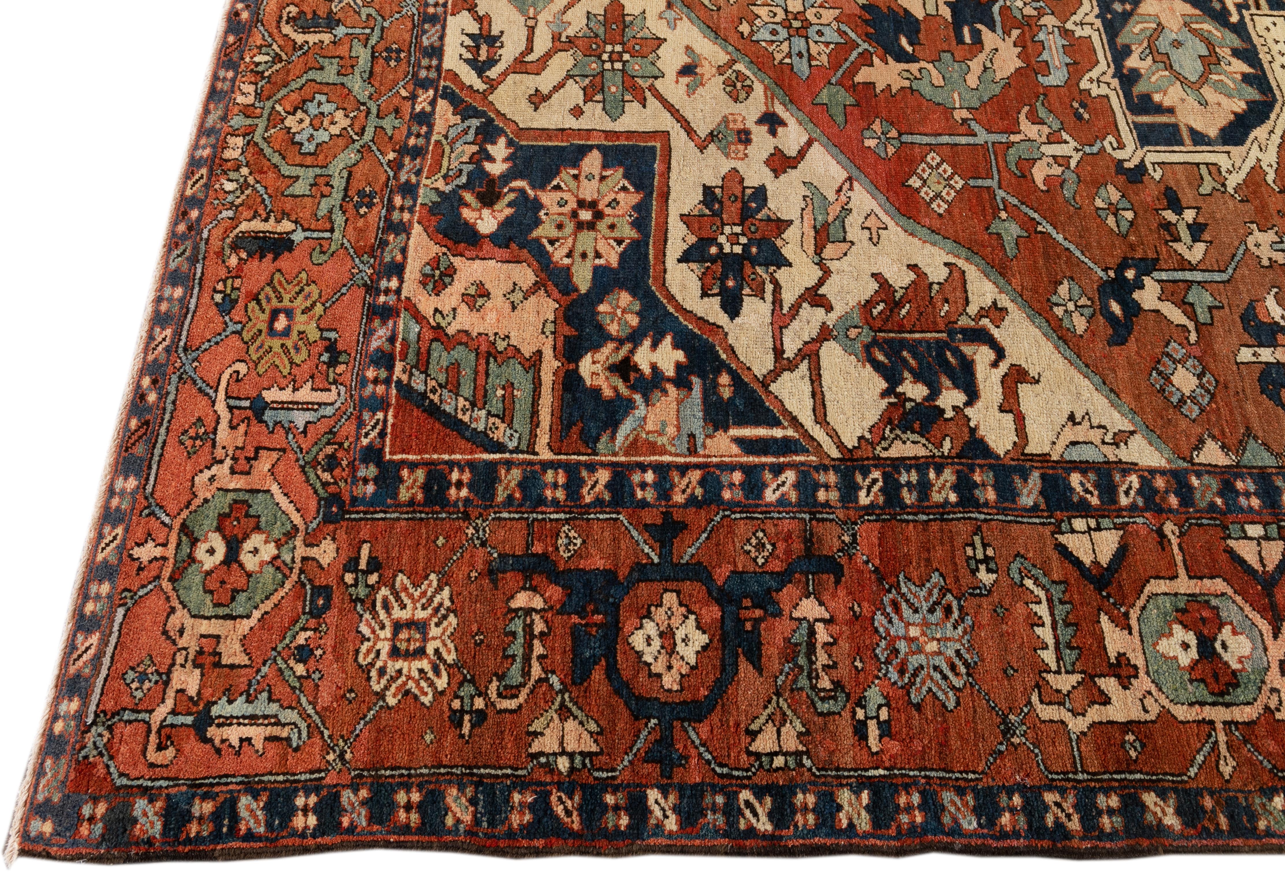Schöner antiker Heriz-Teppich aus handgeknüpfter Wolle mit einem orange-rostfarbenen Feld. Dieser Perserteppich hat dunkelblaue und pfirsichfarbene Akzente in einem prächtigen floralen Medaillon in der Mitte.

Dieser Teppich misst: 10'1