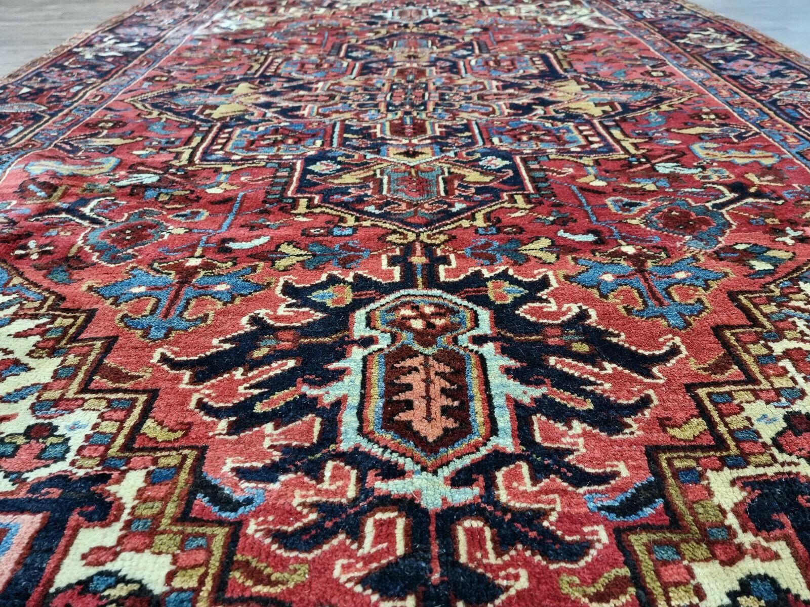 Handmade Antique Persian Style Heriz Rug (5.5’ x 8.8’):

Design and Craftsmanship:
This exquisite rug showcases intricate patterns and designs, reminiscent of traditional Persian artistry.
The central area features a dominant deep blue color,