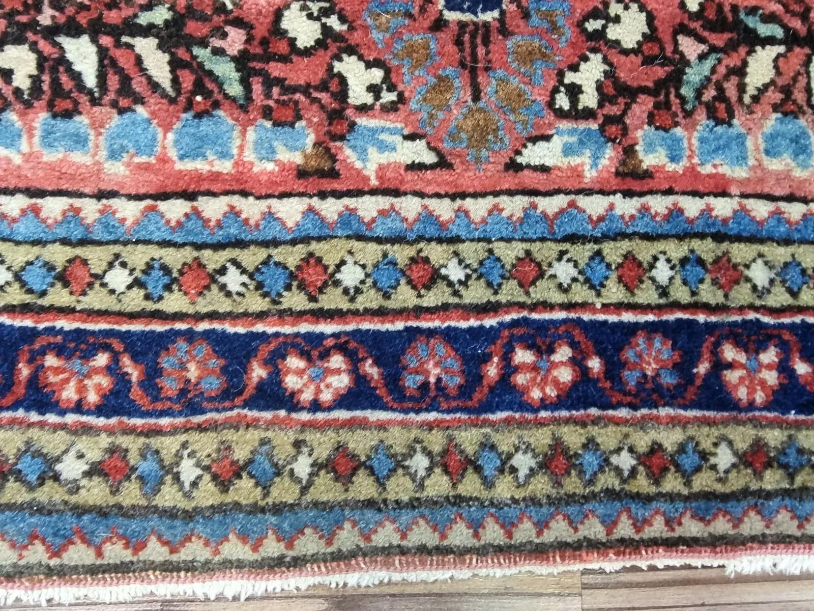 Découvrez une pièce d'artisanat intemporelle avec ce tapis Sarough américain ancien. Noué à la main au début du XXe siècle, il se compose d'un luxueux velours de laine sur une base de coton durable. Ses teintes rouges vibrantes et ses motifs