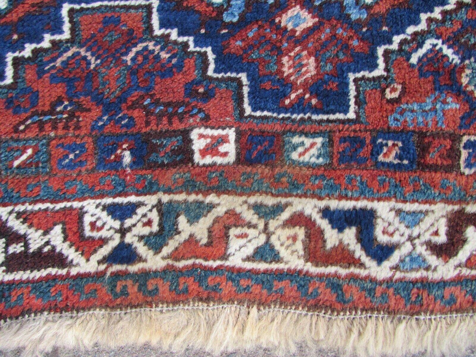 Elevate your home with the timeless charm of this Handmade Antique Persian Style Shiraz Rug. Dating back to the 1920s, this rug measures 3.9' x 4.9', making it a versatile and stylish addition to your decor.

Condition: This antique rug boasts a