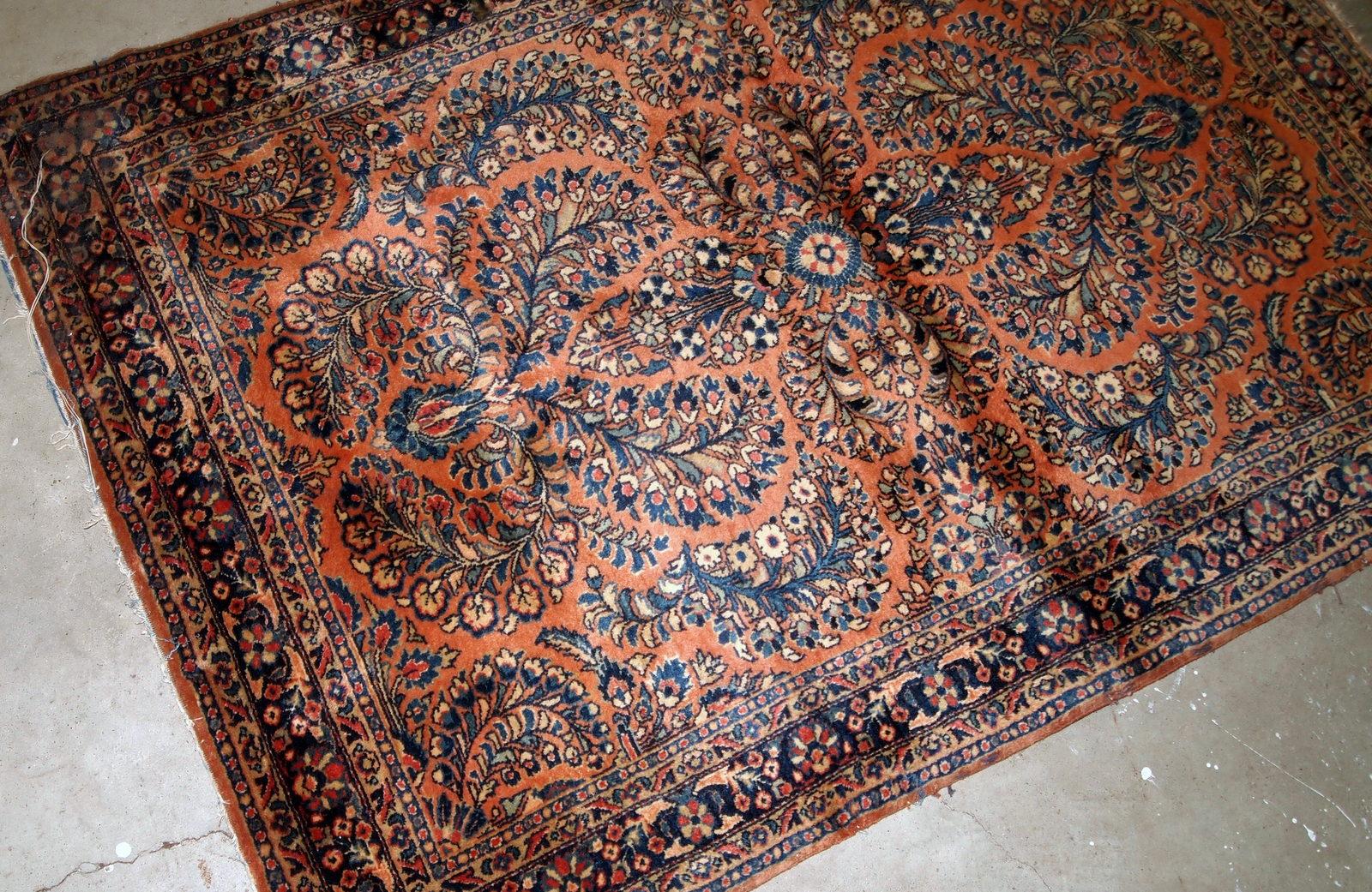 Handmade antique Sarouk style rug in original condition, it as some age wear on one corner. The rug is from the beginning of 20th century made in traditional floral design.

- Condition: Original, some age wear on one corner,

- circa