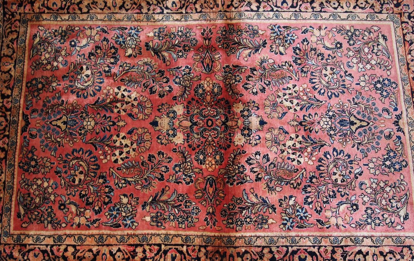 Handmade antique Sarouk style rug in original good condition. The rug is from the beginning of 20th century made in pink shade. 

- Condition: Original good,

- circa 1920s,

- Size: 3.3' x 5.2' (100cm x 158cm),

- Material: Wool,

-