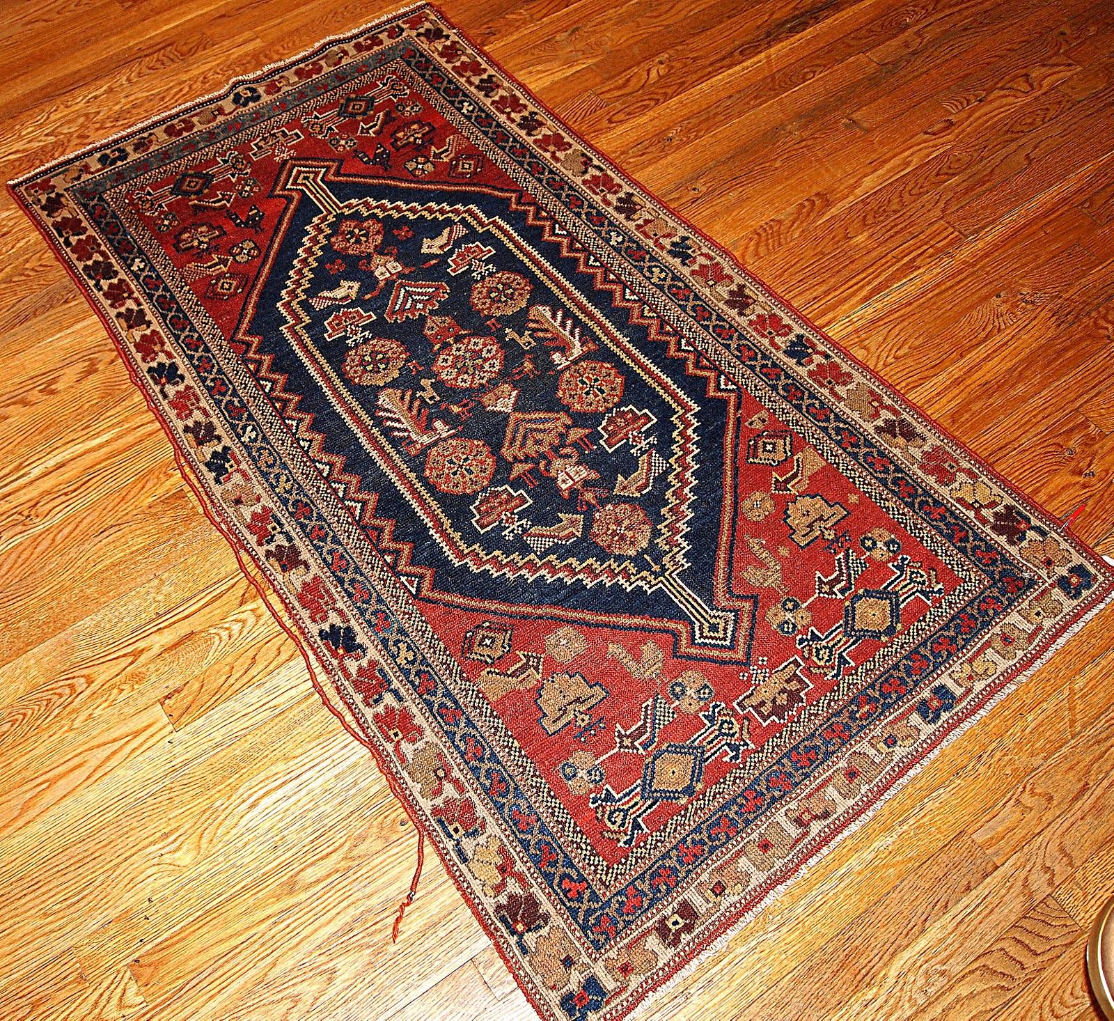 Shiraz rug with a tribal design in navy blue and red shades. This rug is in original good condition.

-Condition: original good,

-Circa: 1920s,

-Size: 3.2' x 5.9' ( 97cm x 180cm ),

-Material: wool,

-Style: Shiraz,

-Background