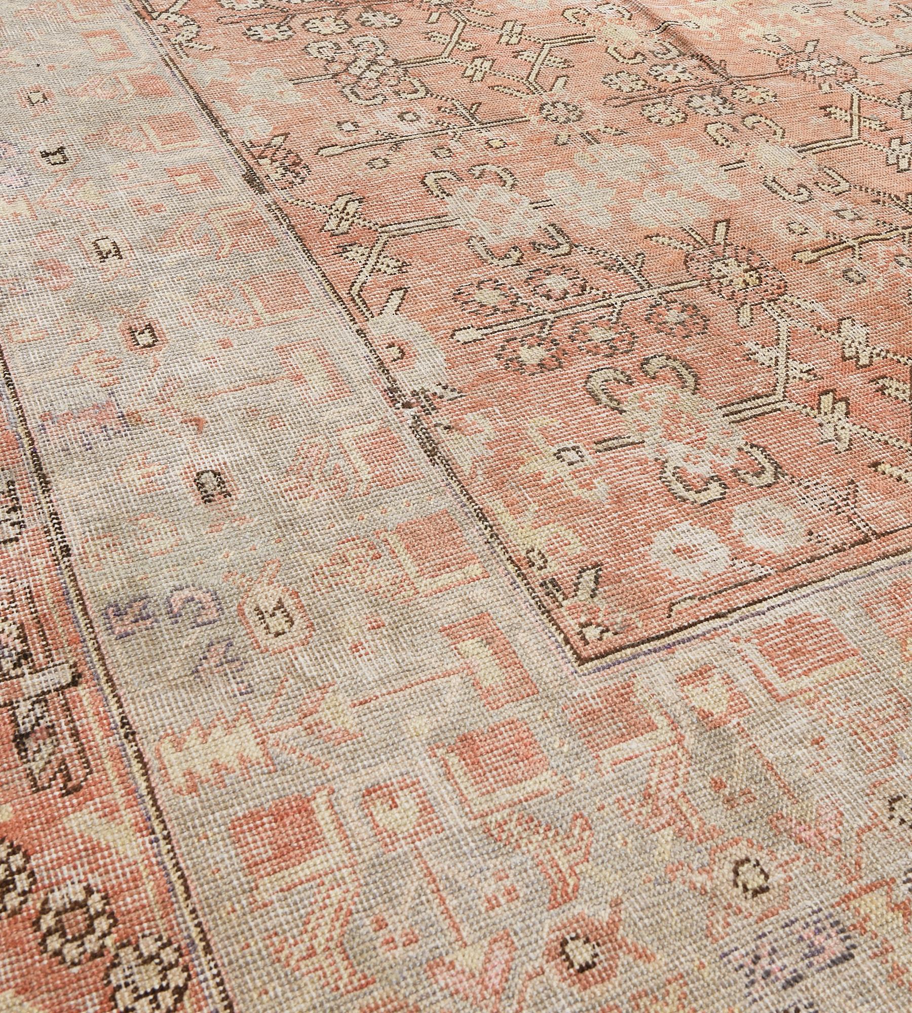 This antique Khotan rug has a light terracotta-red field with an overall design of ivory, buff-brown outlined in chocolate-brown angular palmette and floral vine, in a broad light grey border of light terracotta-red square panels issuing outwards