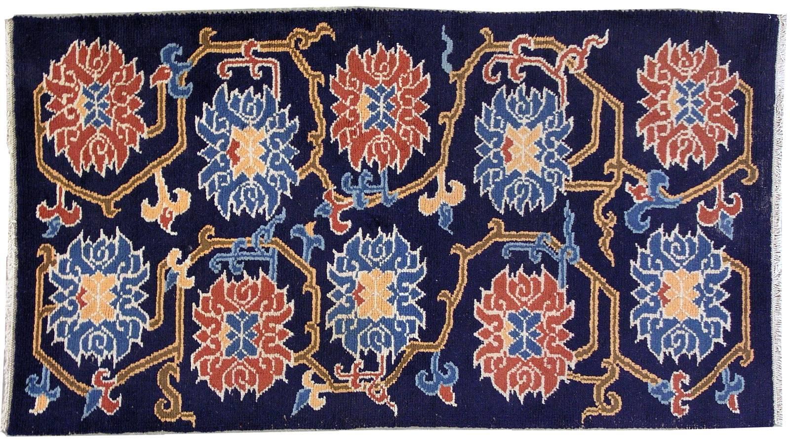 Antique Tibetan rug from Nepal in original good condition. All-over design in navy blue shade decorated with the large flowers in red and sky blue colours. The rug is very abstract and modern for our days. It is in original good condition.
   