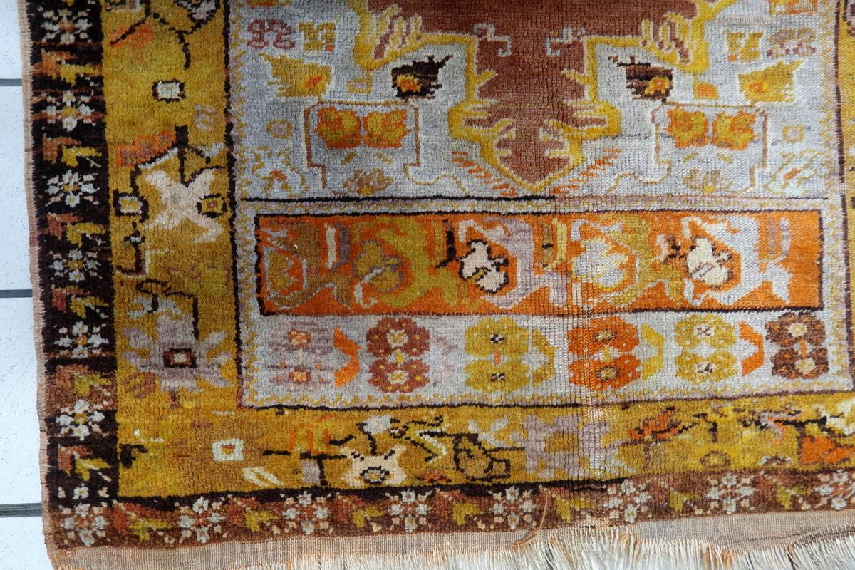 This handmade antique Turkish Anatolian rug, dating back to the 1920s, showcases traditional Anatolian motifs with rich earthy tones and intricate detailing. Made from high-quality wool, it has developed a beautiful patina over time, highlighting
