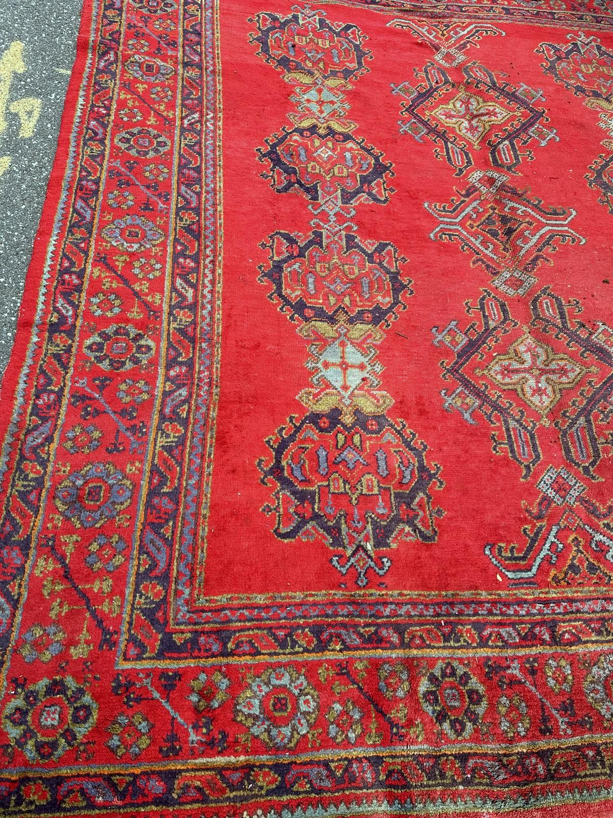 Own a piece of history with this handmade antique Turkish Oushak rug from the 1900s. Crafted from high-quality wool, it measures 8.11 ft x 11.7 ft (247 cm x 356 cm) and features a captivating design with geometric patterns and vibrant hues,