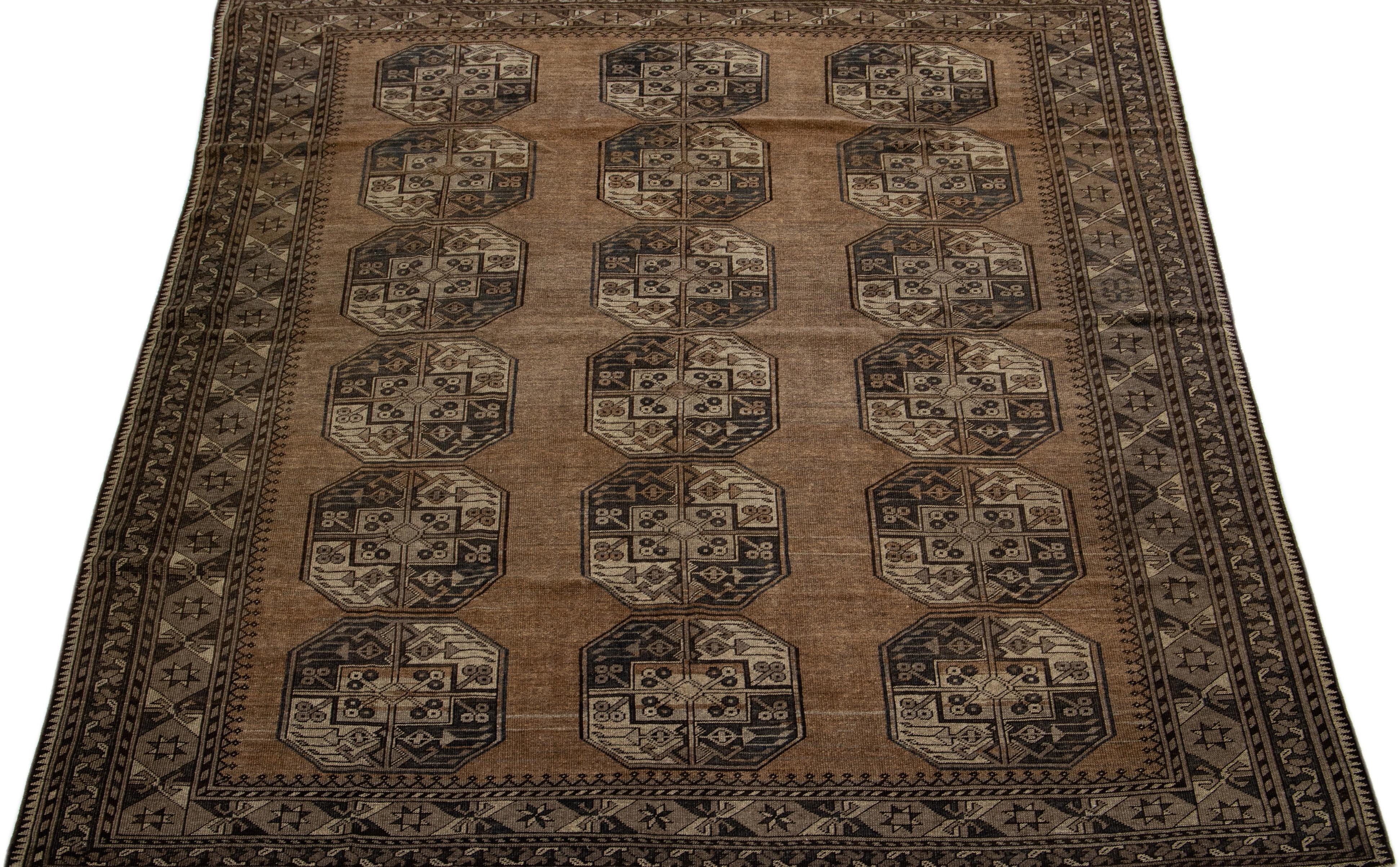 Beautiful antique Turkmen hand-knotted wool rug with a brown color field. This Persian piece has a gorgeous Gul pattern design in beige and gray.

This rug measures: 7'2