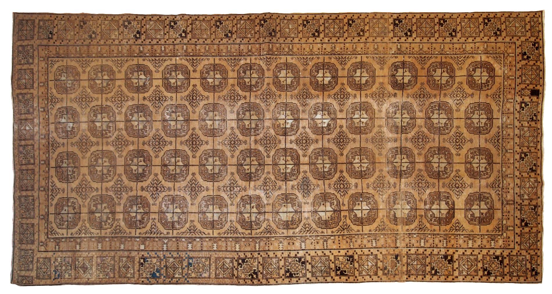 Handmade antique East Turkestan distressed rug with repeating pattern. It is in brown shade, made in the beginning of 20th century.
 