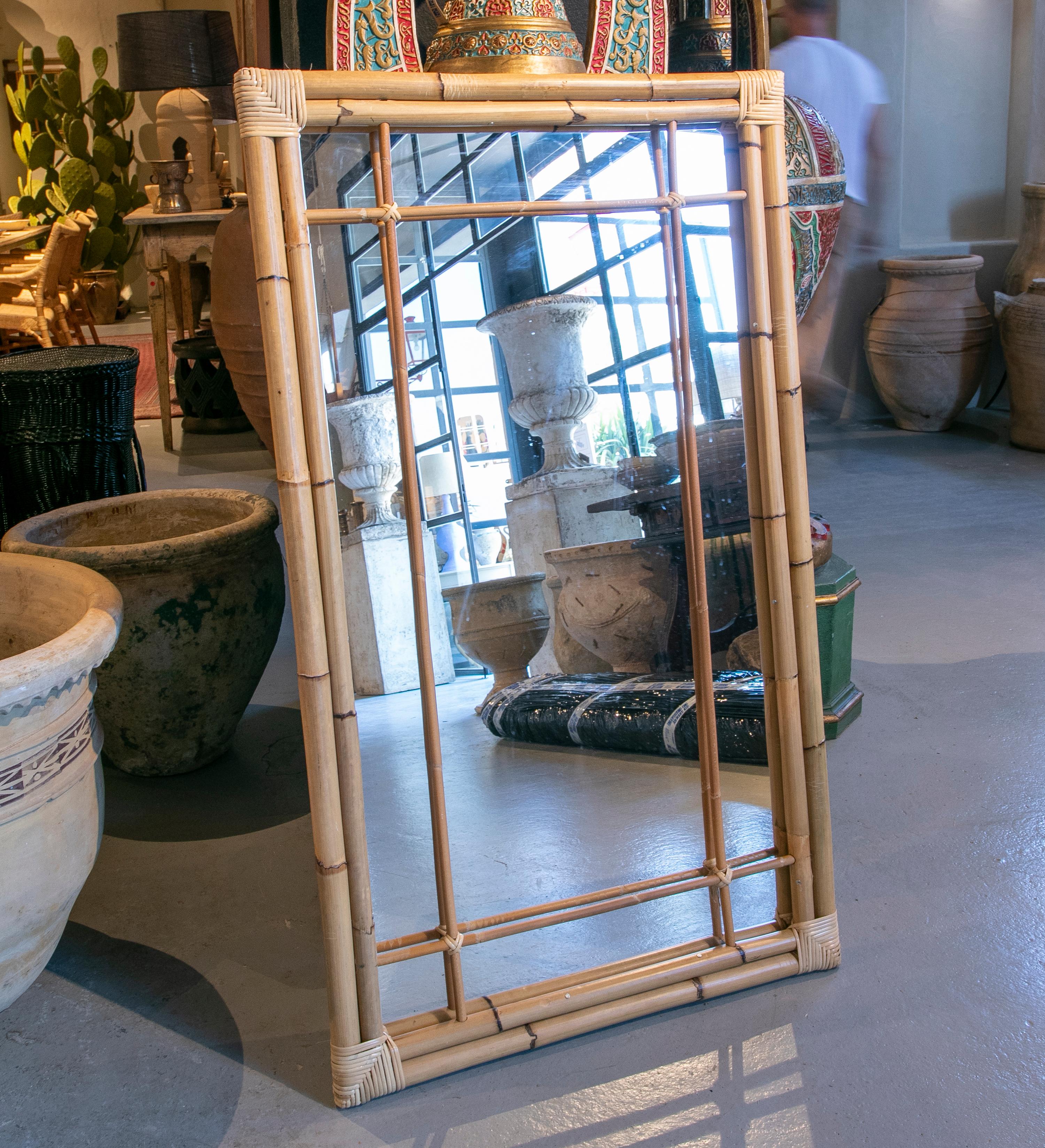 Handmade bamboo mirror with a double frame in the outside and a thin decoration, in the same material, in the inside.