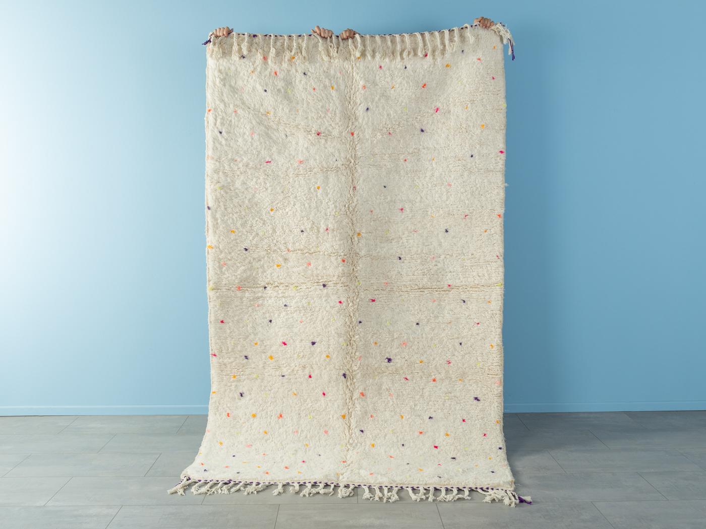 Tiny Polka Dots II ist ein moderner Teppich aus 100 % Wolle - dick und weich, angenehm zu tragen. Unsere Berberteppiche werden von Amazigh-Frauen im Atlasgebirge handgewebt und handgeknüpft. Diese Gemeinschaften stellen schon seit Tausenden von