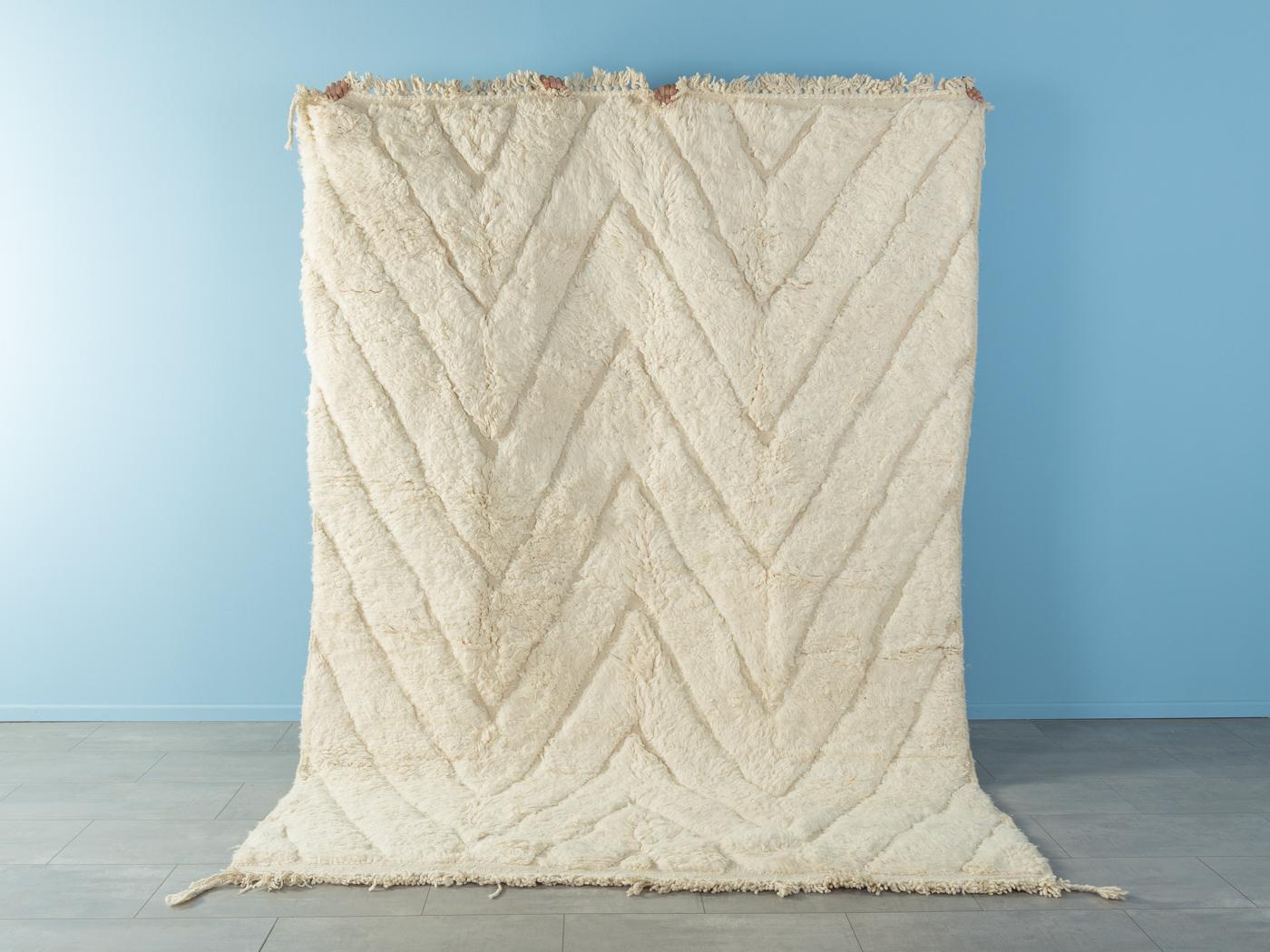 Decent Triangle ist ein moderner Teppich aus 100 % Wolle - dick und weich, angenehm zu tragen. Unsere Berberteppiche werden von Amazigh-Frauen im Atlasgebirge handgewebt und handgeknüpft. Diese Gemeinschaften stellen schon seit Tausenden von Jahren