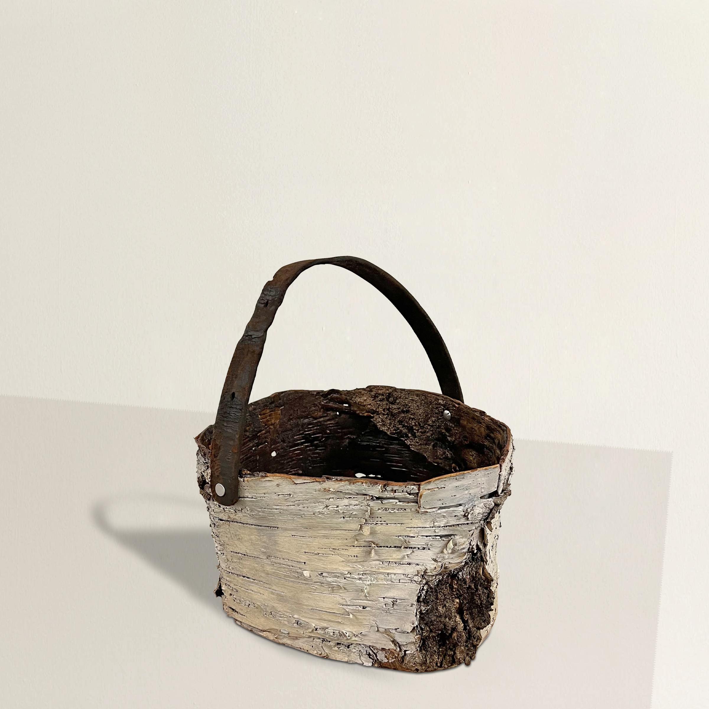 Indulge in the rustic elegance of this handmade birch bark bucket, discovered in the heart of Wisconsin. Inspired by the time-honored traditions of Native American basketry in the region, this exquisite piece seamlessly blends history with modern