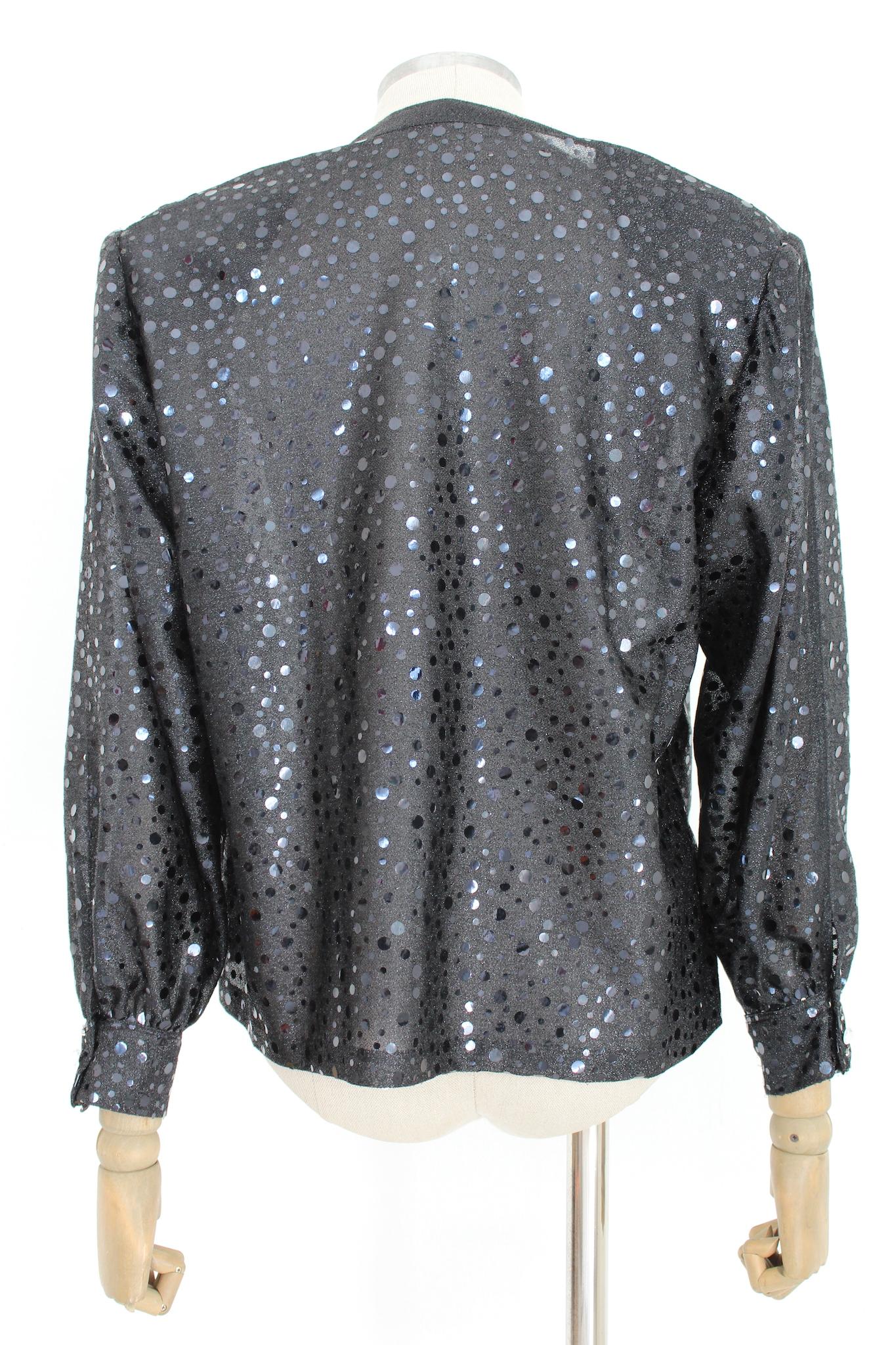 Vintage 80s black sequins handmade shirt. Evening under jacket in shiny fabric with V-neckline. Asymmetrical rhinestones and applied clasps. Large 80's shoulder straps, polyester fabric. Made in Italy.

Size: 46 It 12 Us 14 Uk

Shoulder: 46 cm
Bust