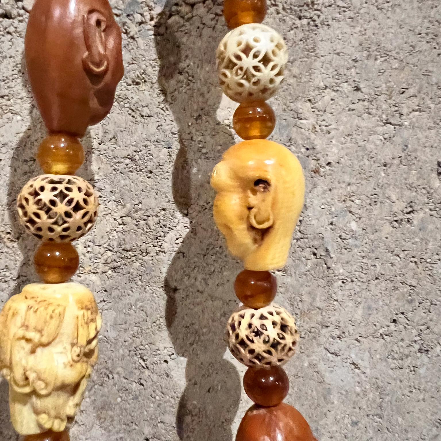 AMBIANIC presents Chinese Dynasty Beaded Necklace 18 Arhat Rohan
Brown and white hand carved peach pit, carved bone and figure heads amber beads
.75 thick 22.5 long
Preowned vintage
Refer to images provided