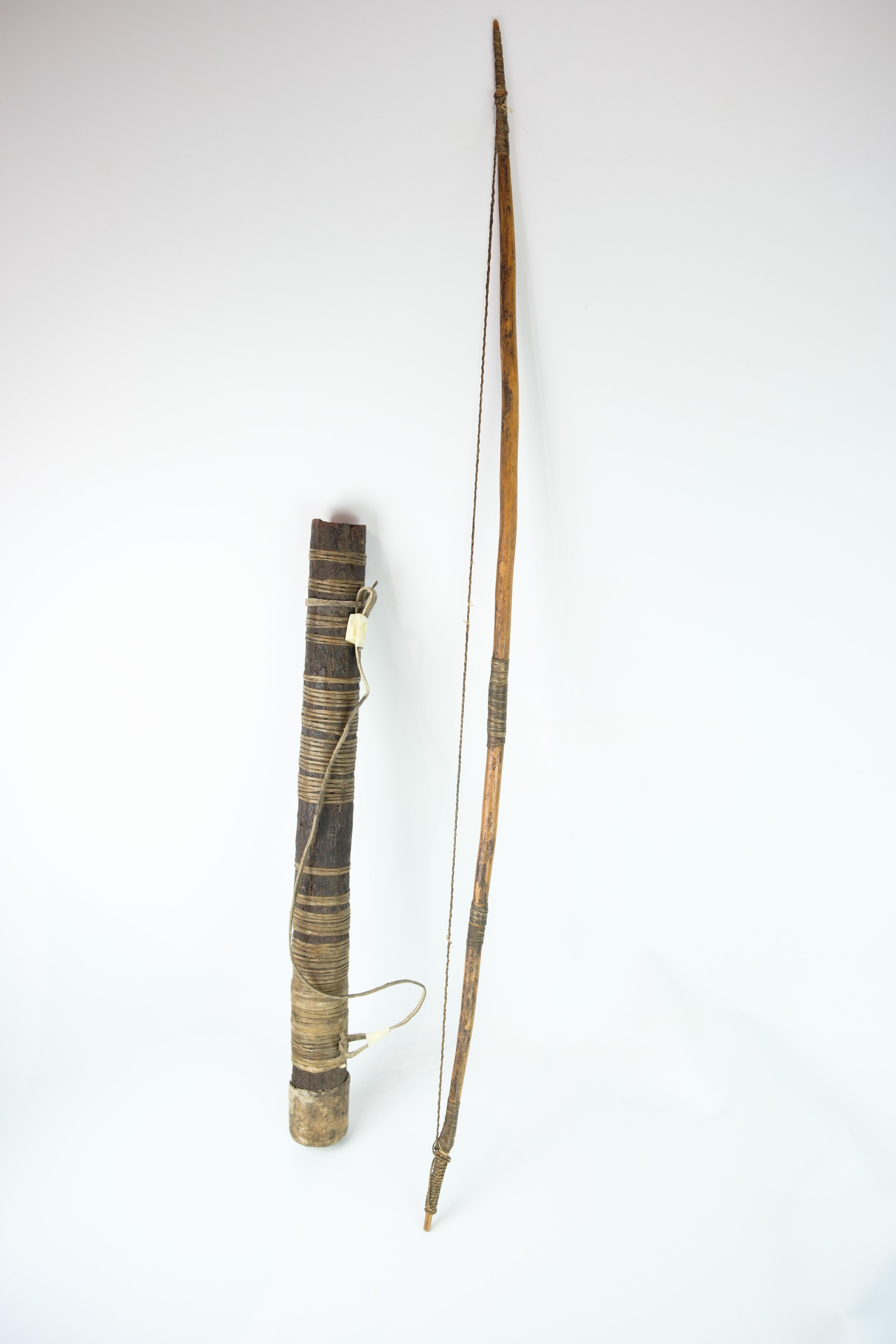 Handmade bow and arrow sheath from Africa, made of natural materials. The bow is made of wood with a string of twisted plant fibers and decorated with traditional windings. The arrow sheath is wrapped with organic material and provided with a
