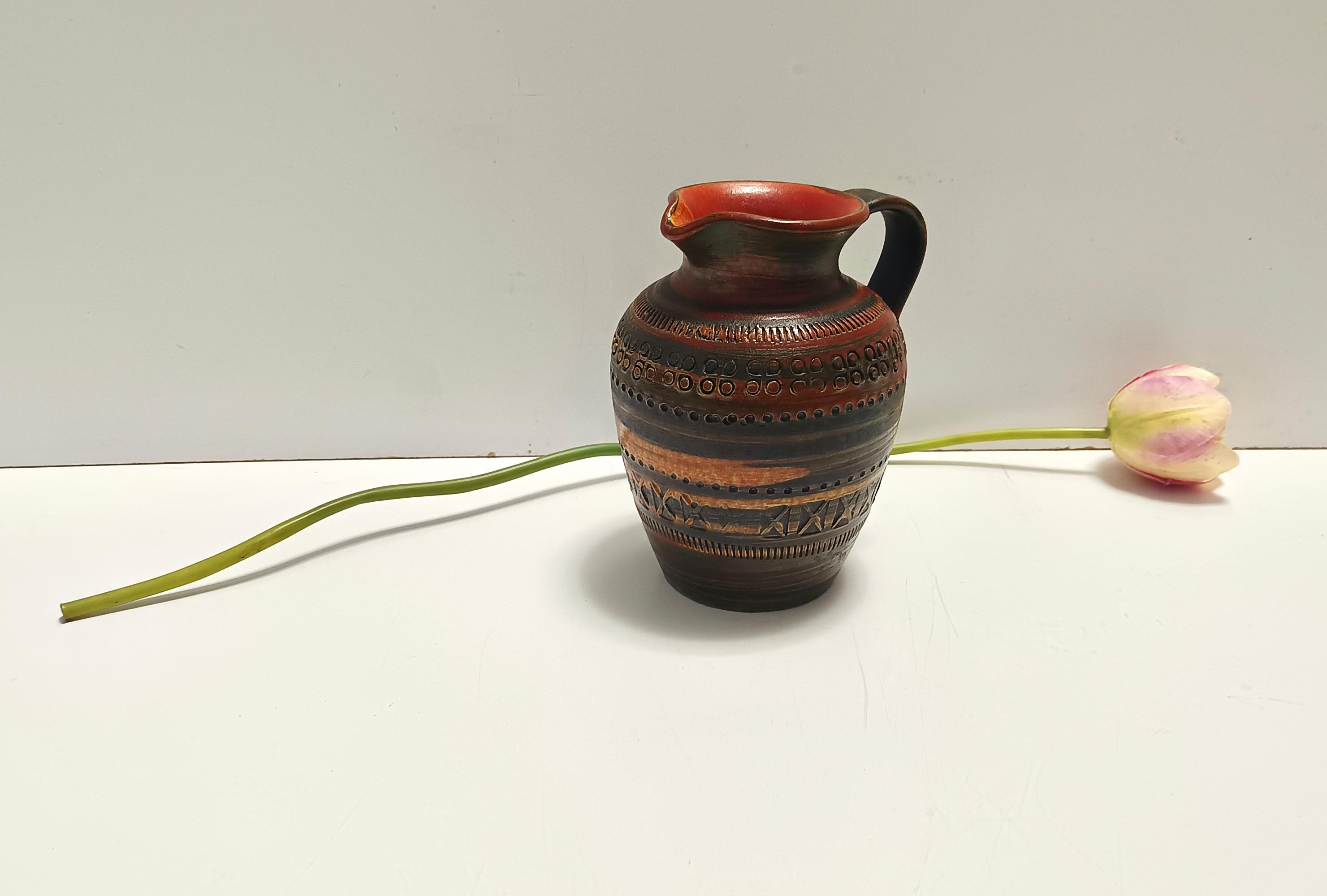 Handgefertigt in Italien, 1970er Jahre.
Dieser Krug ist aus lackiertem Steingut mit braunen und orangefarbenen Schattierungen hergestellt, die seltene Farben sind.
Da es sich um einen Vintage-Artikel handelt, kann er leichte Gebrauchsspuren