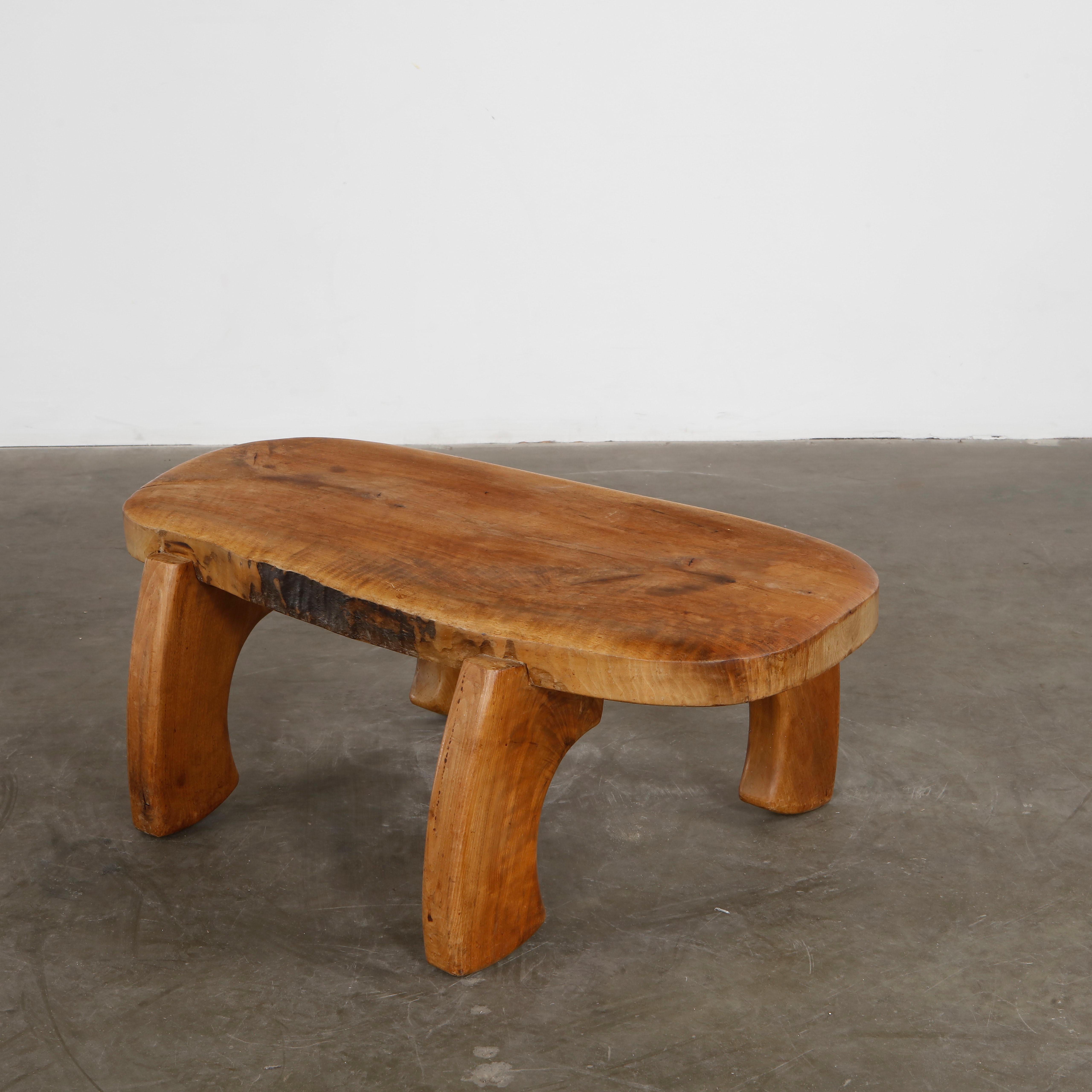 Chunky elm wood table with arched legs and hand-sculpted surface. Unique artisan work. Height: 14.5 in. Width: 40 in. Depth: 21 in.