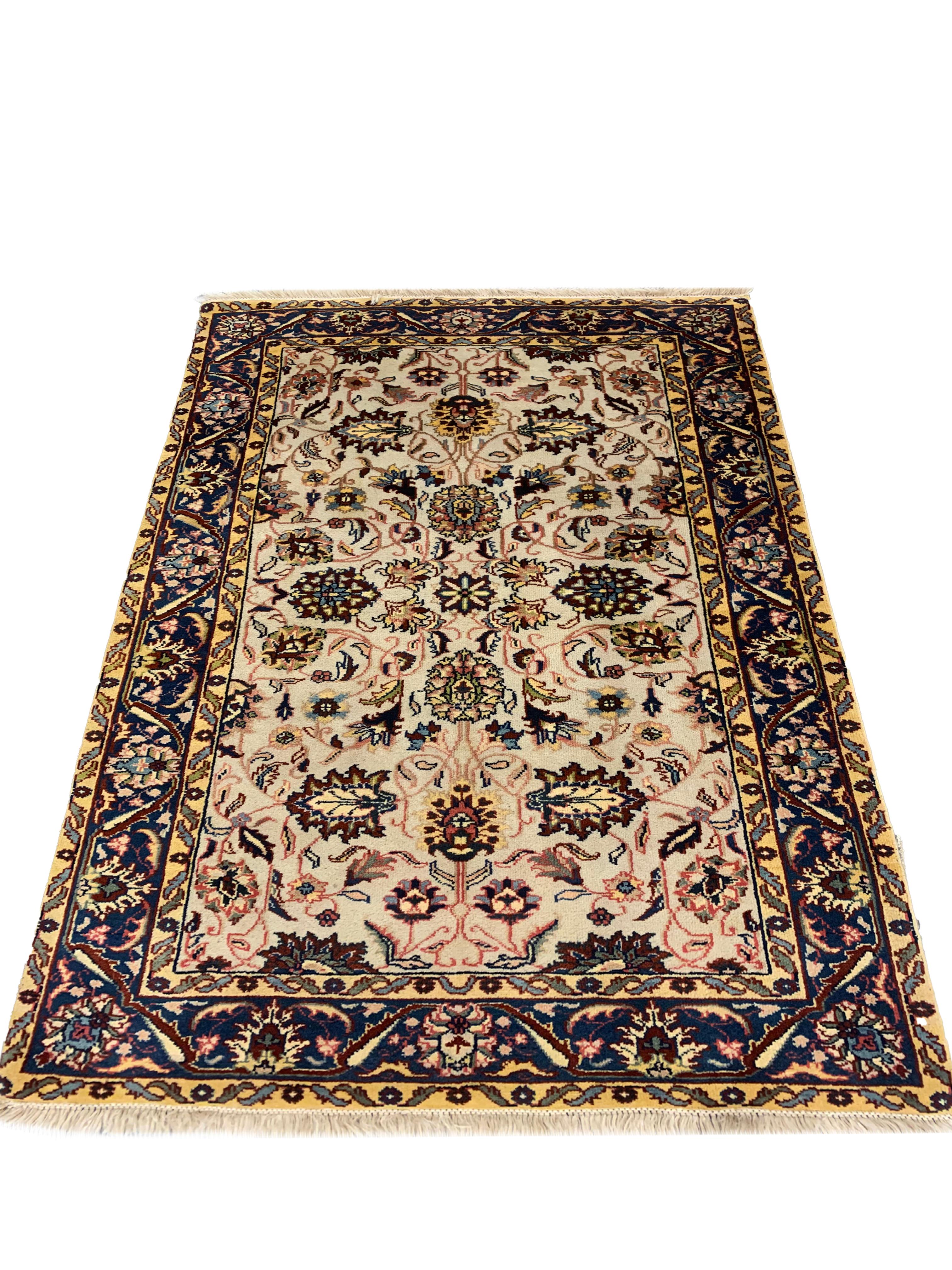 This fine wool area rug is an excellent example of rugs woven by hand in India. This vintage rug features a traditional Indian design featuring a symmetrical floral design woven in accents of yellow, red, blue and green. Both the colour palette and