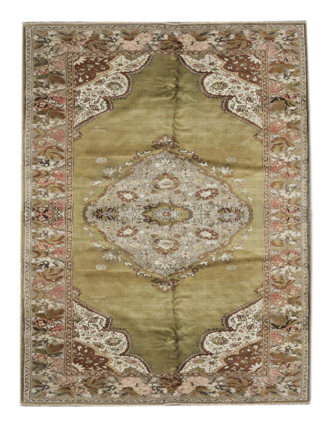 Handmade carpet muted olive green, pink and beige tones sit in harmony on this large area rug—Handwoven with the finest handspun cotton and wool dyed using organic vegetable dyes. A large central medallion makes this handmade rug stand out in any