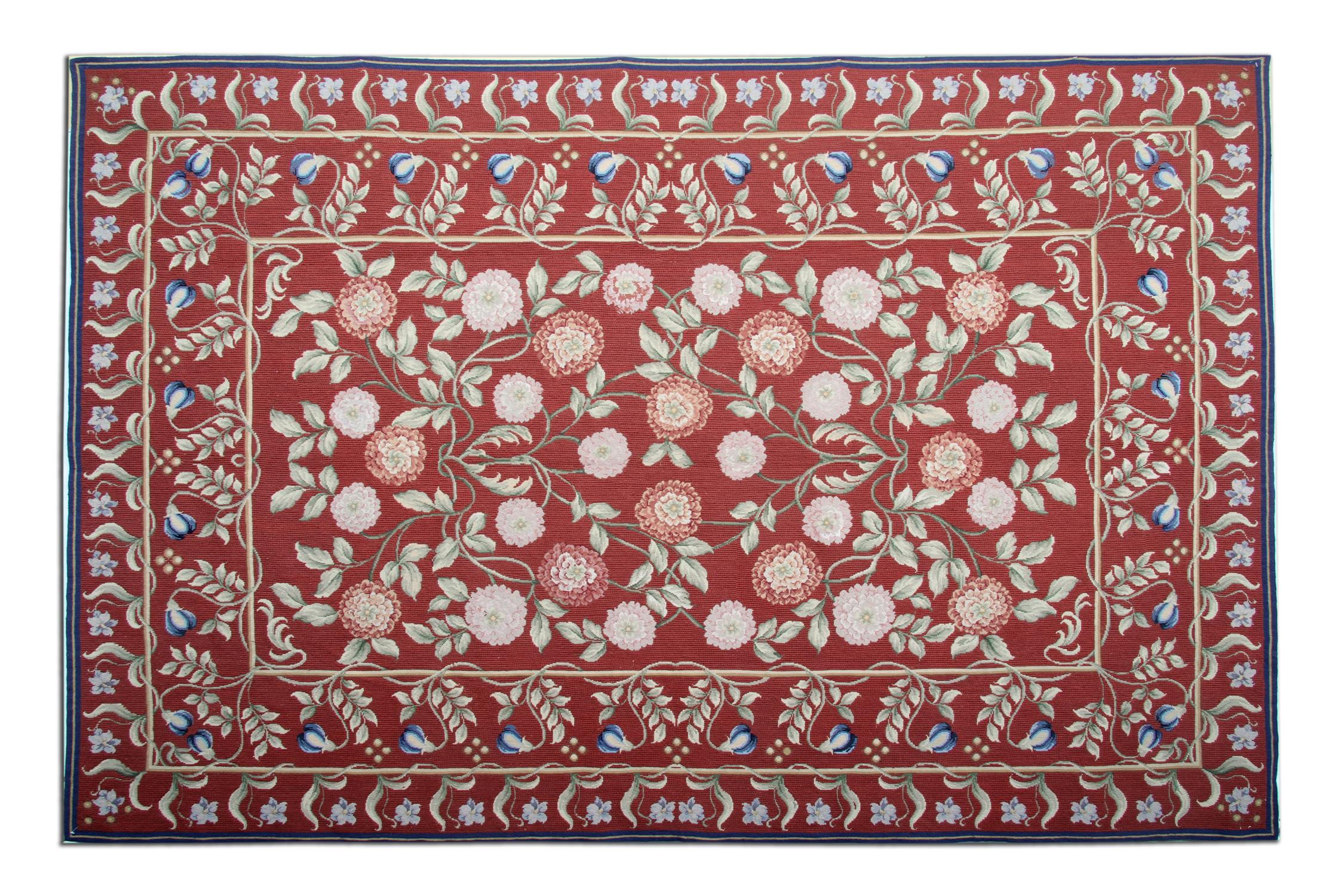 This beautifully handwoven Aubusson rug is sure to make a great accent piece in any room it’s introduced too. Deep red sits as the background colour, which has then been decorated with a pink, green and blue, symmetrical floral arrangement. The