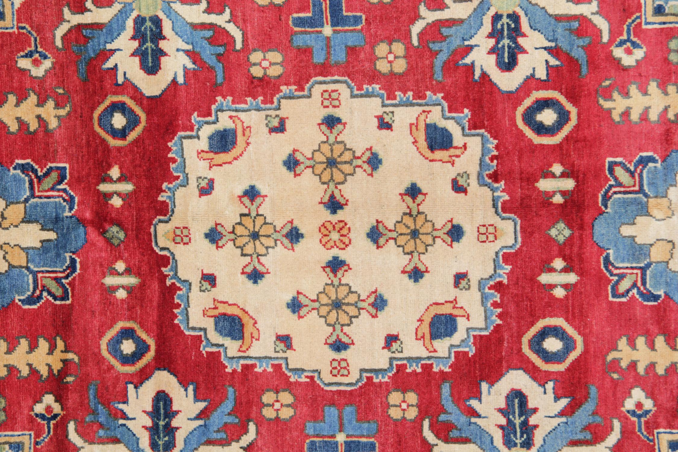 This is an example of a handwoven rug which features designs from the Kazak region. The Afghan weavers used top quality wool and cotton to produce this red rug. This tribal rug features typical geometric rug patterns. There are a variety of colours