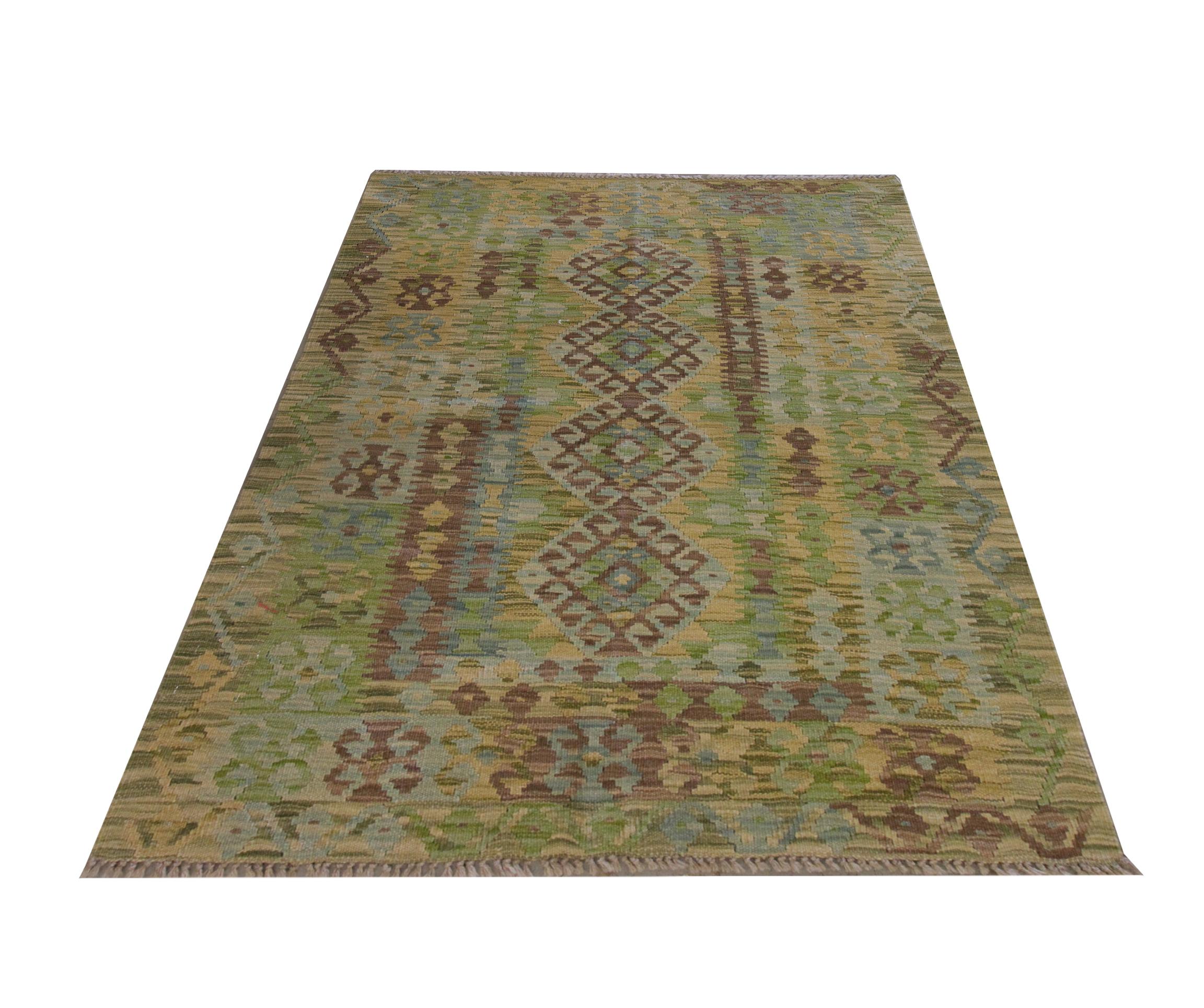 This luxurious green Kilim is a traditional afghan Kilim woven by hand in the early 21st century. Woven with a bold geometric pattern that features hook medallions and diamond motifs in accents of beige, blue and blue. The symmetrical design and