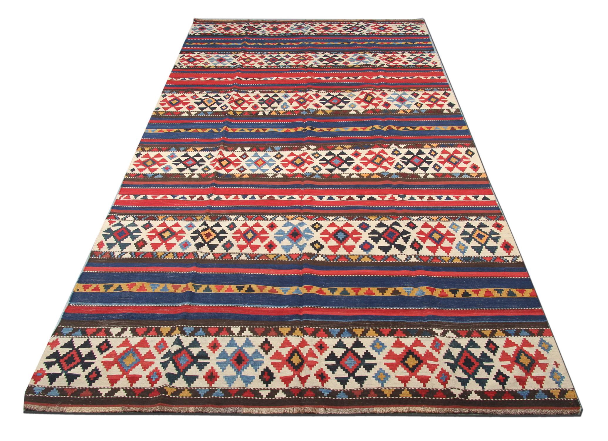 Dieser alte kaukasische Schirwan-Teppich wurde in den 1940er Jahren mit einem fantastischen geometrischen Streifendesign handgewebt. Das Streifenmuster wurde mit roten und blauen Akzenten gewebt und weist elfenbeinfarbene Felder mit geometrischen