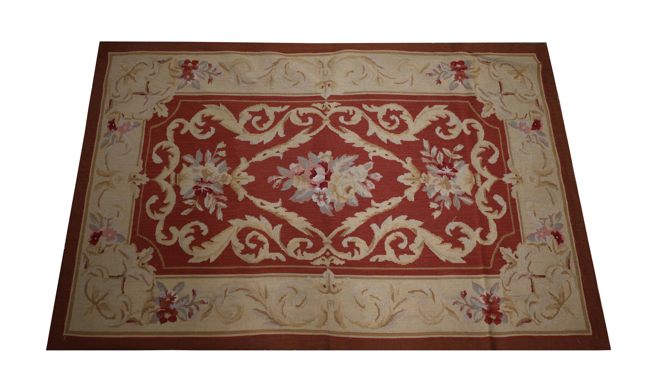 This New English style needlepoint was handwoven in the early 21st century and featured a traditional country house design with a scroll and flower central design and symmetrical surrounding pattern. Woven with an elegant colour palette of deep red,