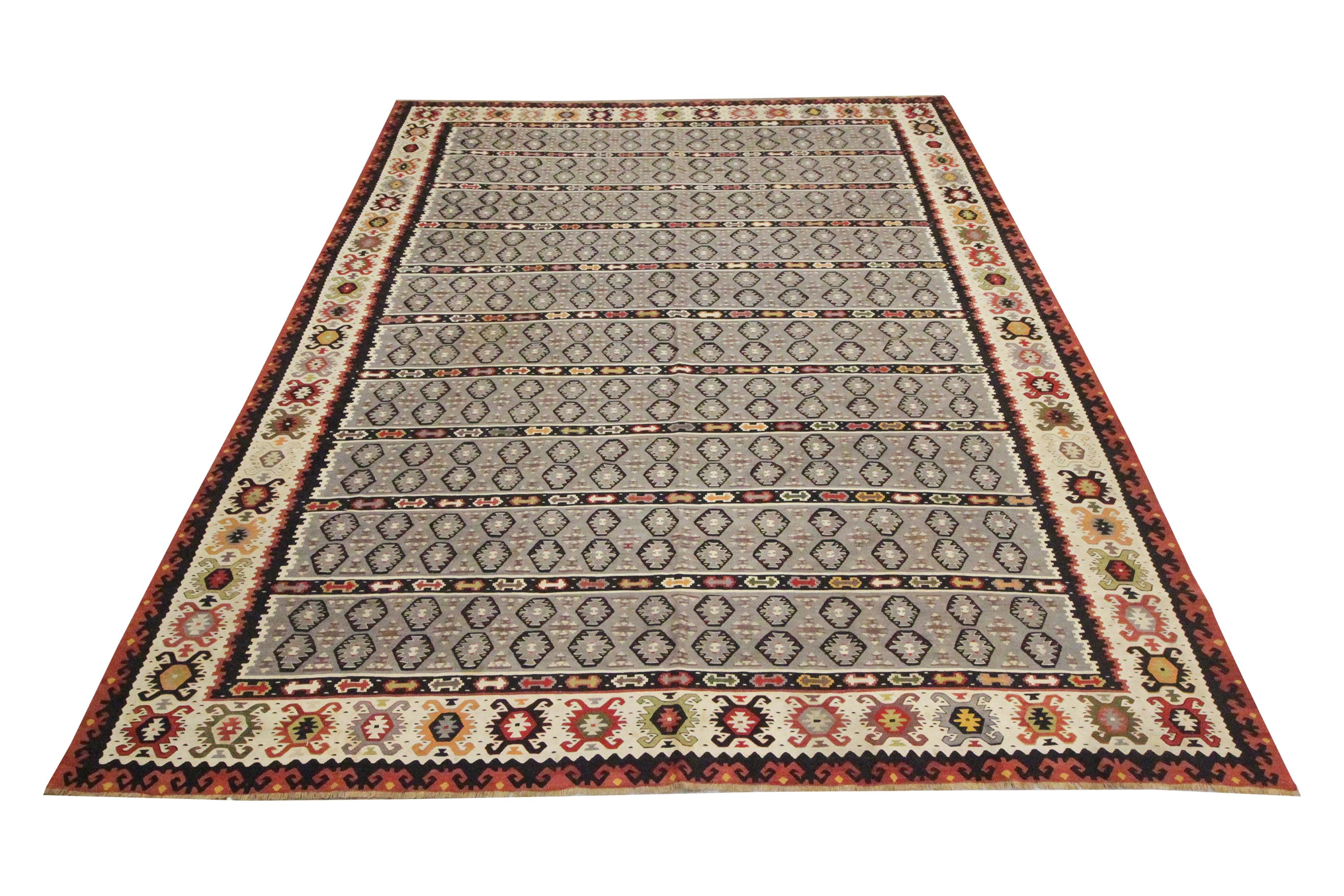 Looking for a new area rug to uplift your space? This bold antique Serbian carpet is sure to do just that. Grey, cream and rust accents make up the main colours in this elegant blue wool rug. The striped rug is woven with a grand repeating central