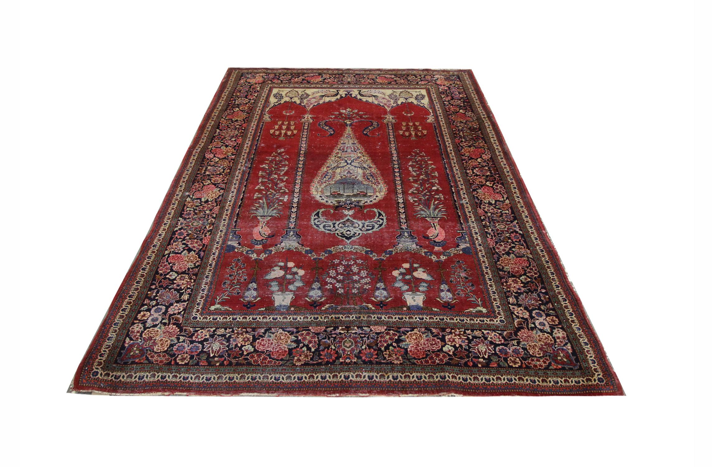 The border of this oriental rug is rich in floral design, intricately woven on a background of black so the beautiful colors pop. The central design of this rug sits on a deep red background and has detailed designs of chandeliers, tree of life,