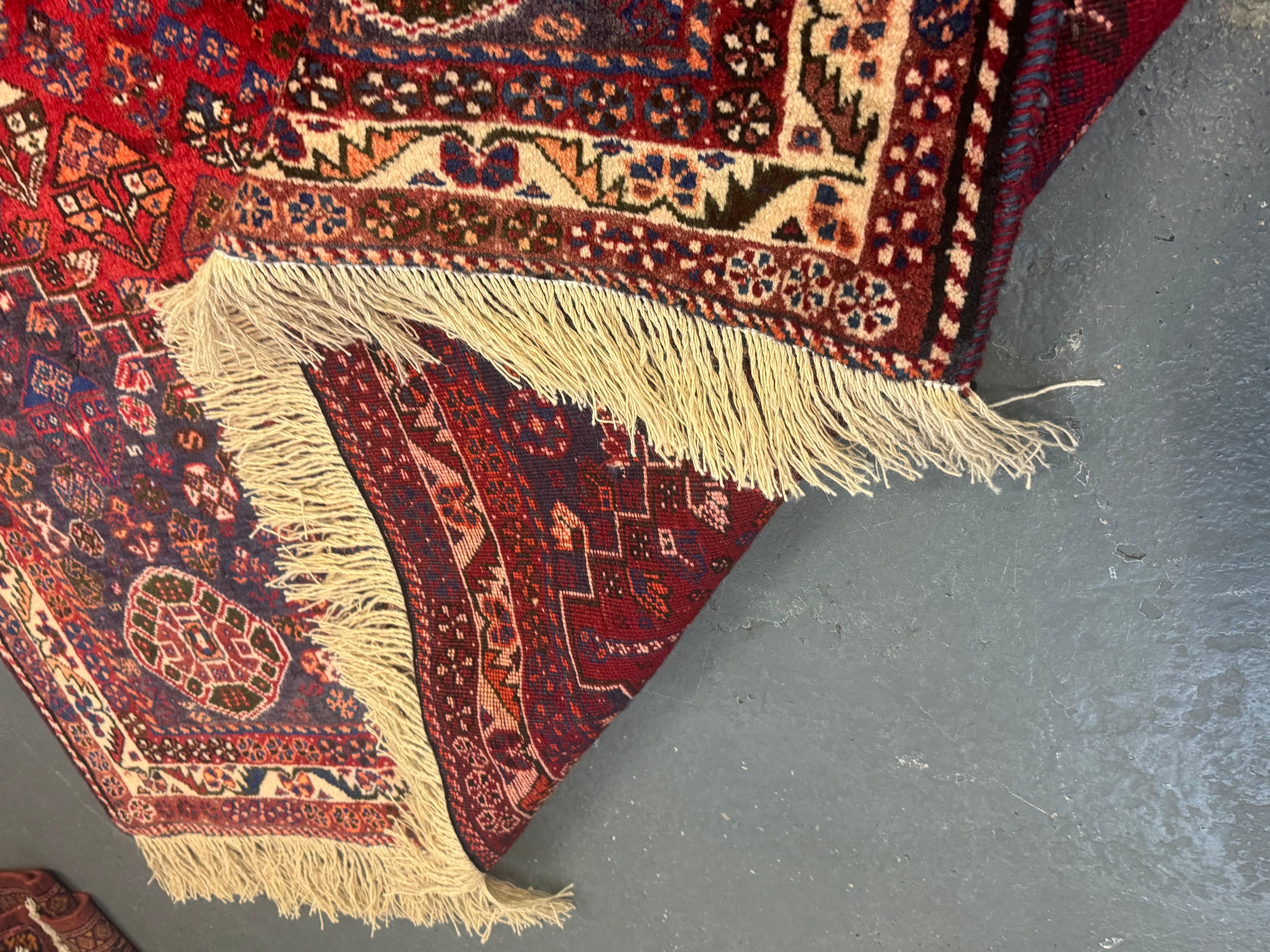 Esta alfombra tradicional Qashqai se tejió a mano en la década de 1950. El diseño del medallón principal presenta un patrón geométrico y pequeñas plantas y flores reapeatativas con una combinación de colores única y diferentes animales abstractos a