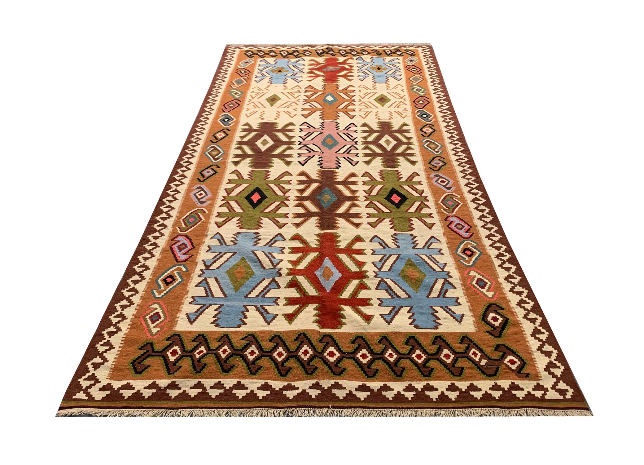 This elegant handwoven wool area rug was constructed in the late 20th century around 1980 in Turkey. The design features cream, brown, blue and rust colours that make up the fantastic elegant repeat pattern tribal design. Both the colour and design