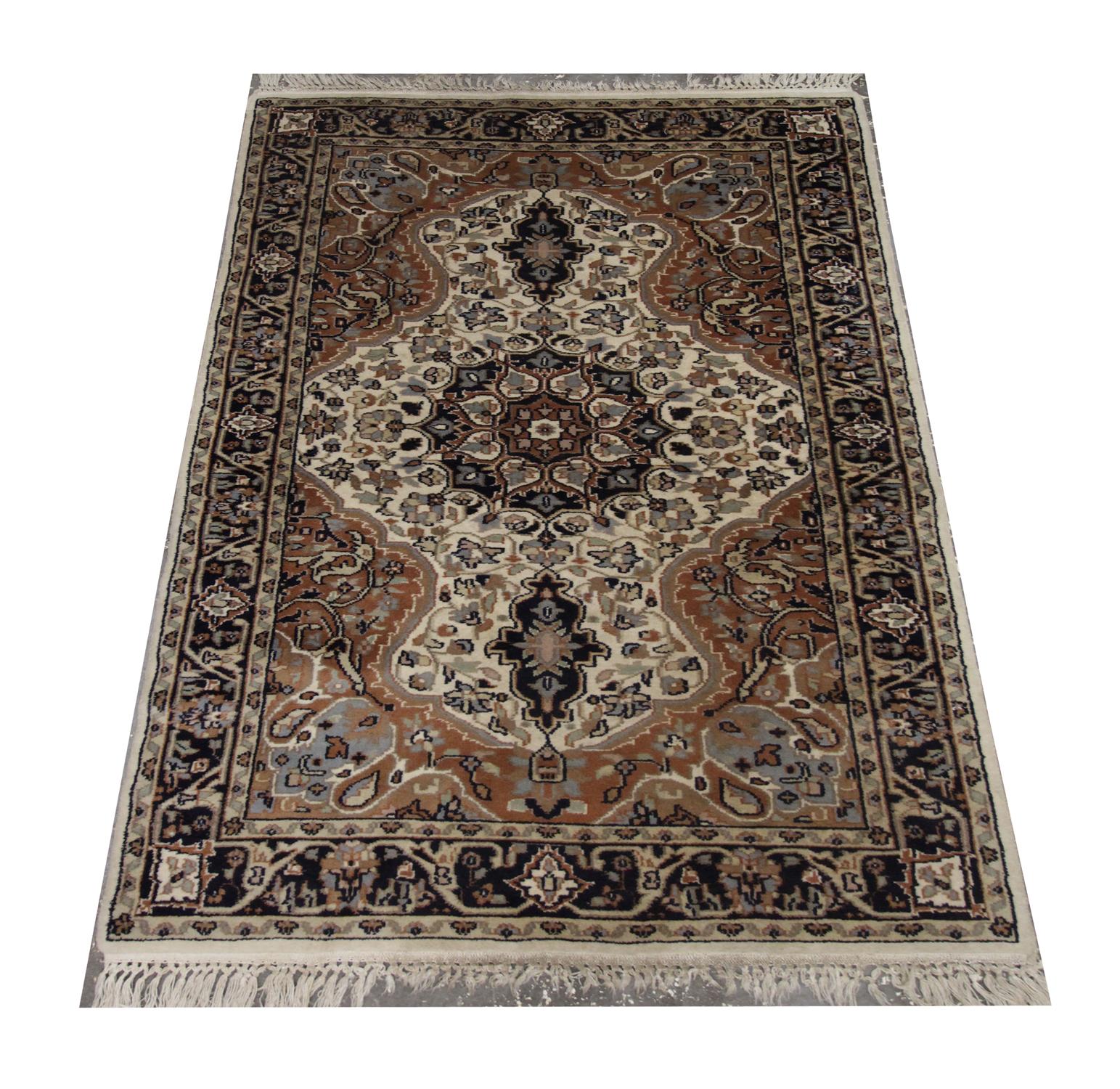 This Oriental rug vintage Indian rug was handwoven in 1890 with a highly-detailed central medallion design. Floral motifs meander from the centre in various colors of black, cream, grey and beige. This symmetrical design has been intricately woven.