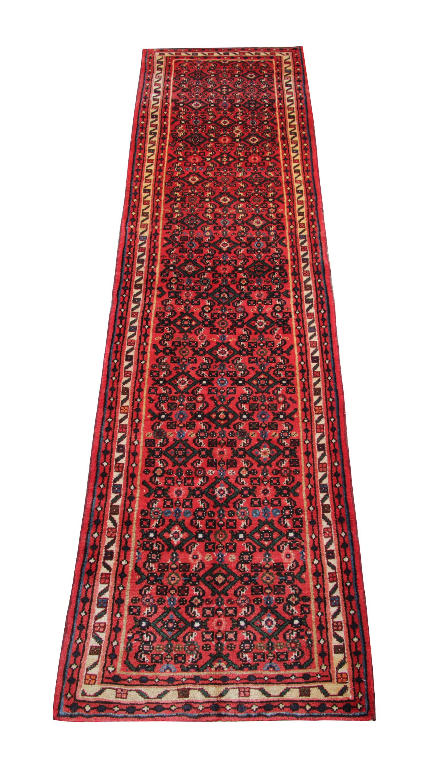 This vintage wool runner rug was woven by hand in the 1960s and featured a rich red background and geometric design made up of brown and beige accent colours. Constructed with the finest organic materials, including hand-spun wool, which has been