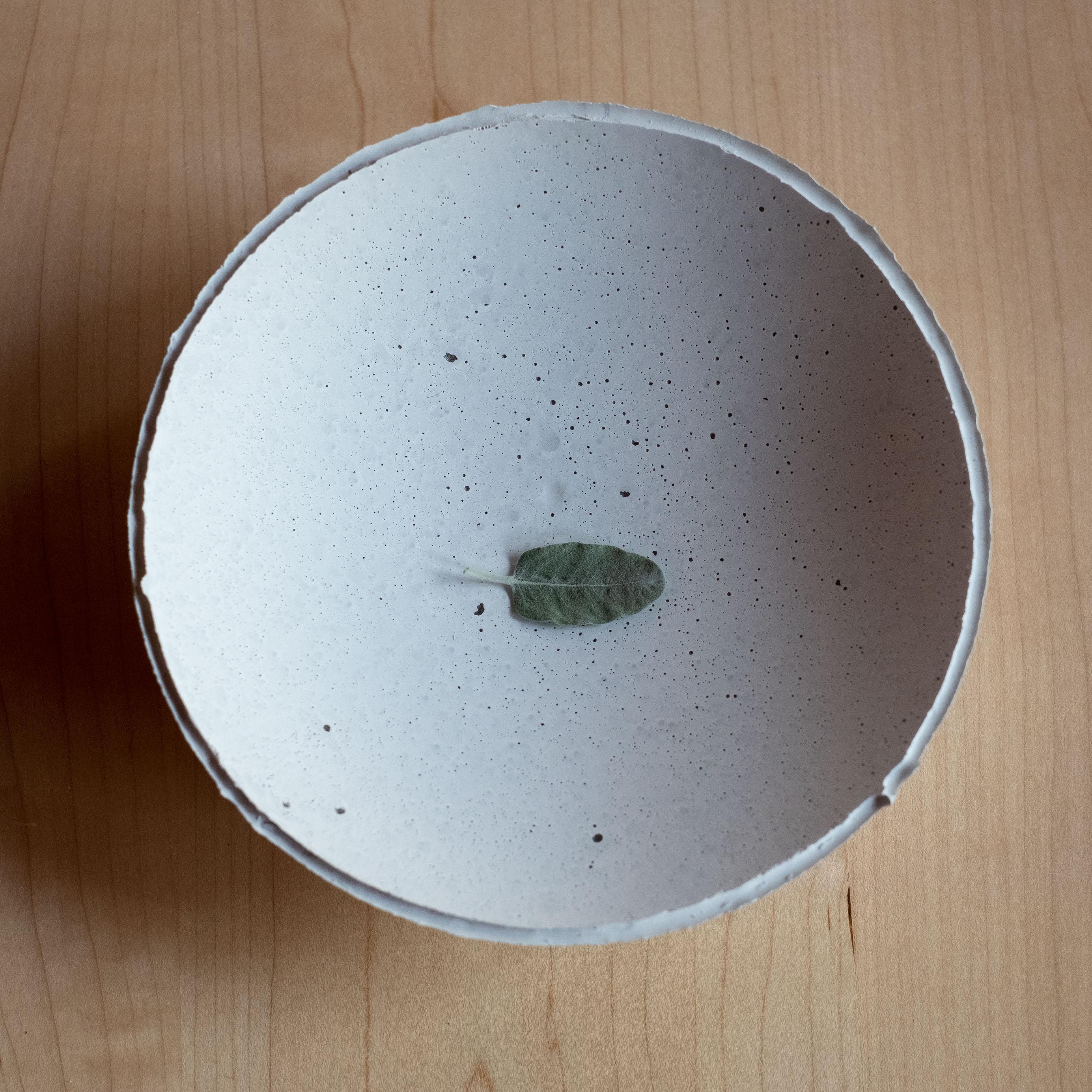 La série Concrete d'UMÉ Studio, une édition de 150 bols uniques, exprime la tension entre le béton lourd et son bord délicat généré par le coulage à la main. Alors que l'on suppose que le béton devrait être solide et durable, il est, au fond,