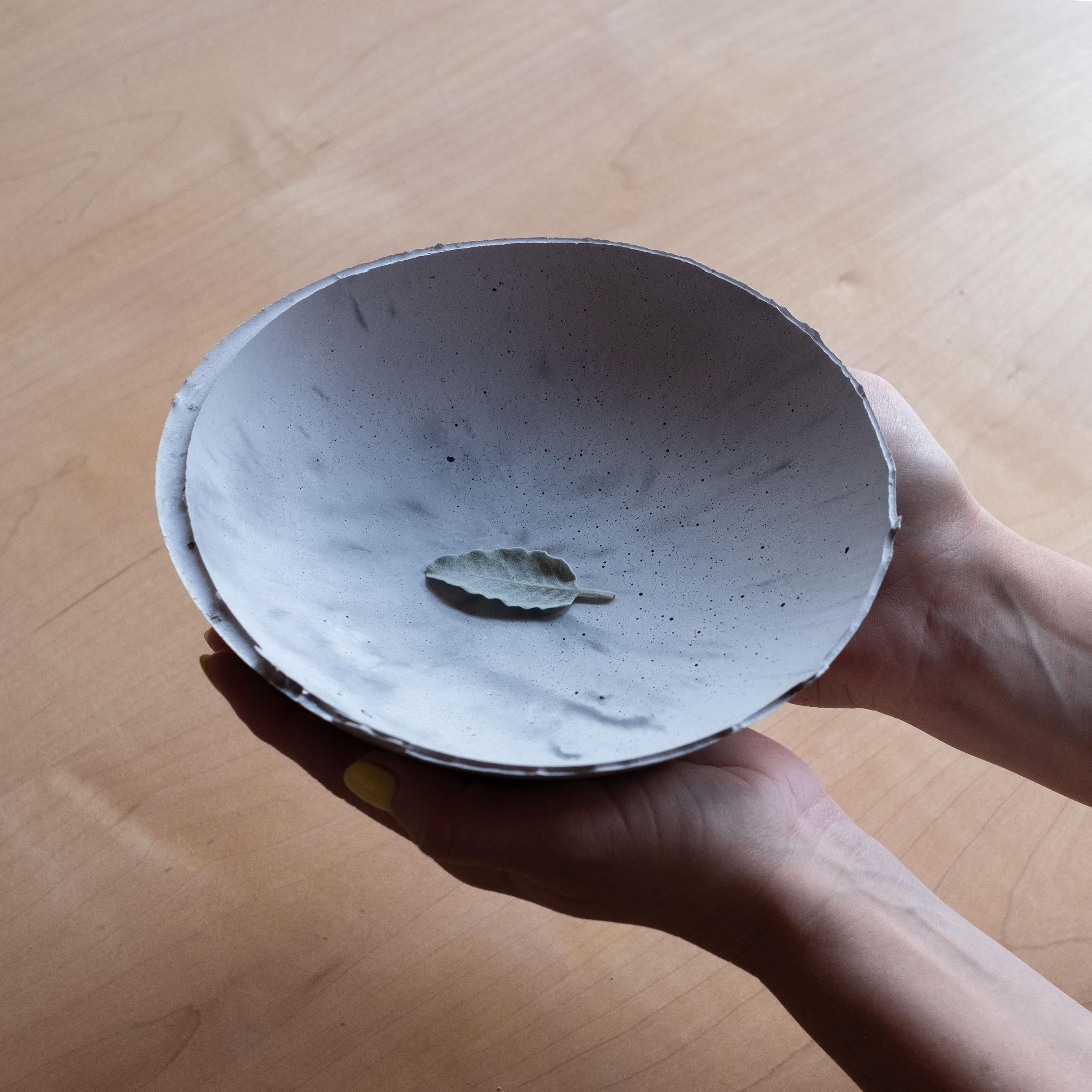 Une édition de 150 bols uniques, la Série béton d'UMÉ Studio exprime la tension entre le béton lourd et son arête délicate générée par le coulage à la main. Alors que l'on suppose que le béton devrait être solide et durable, il est, au fond,