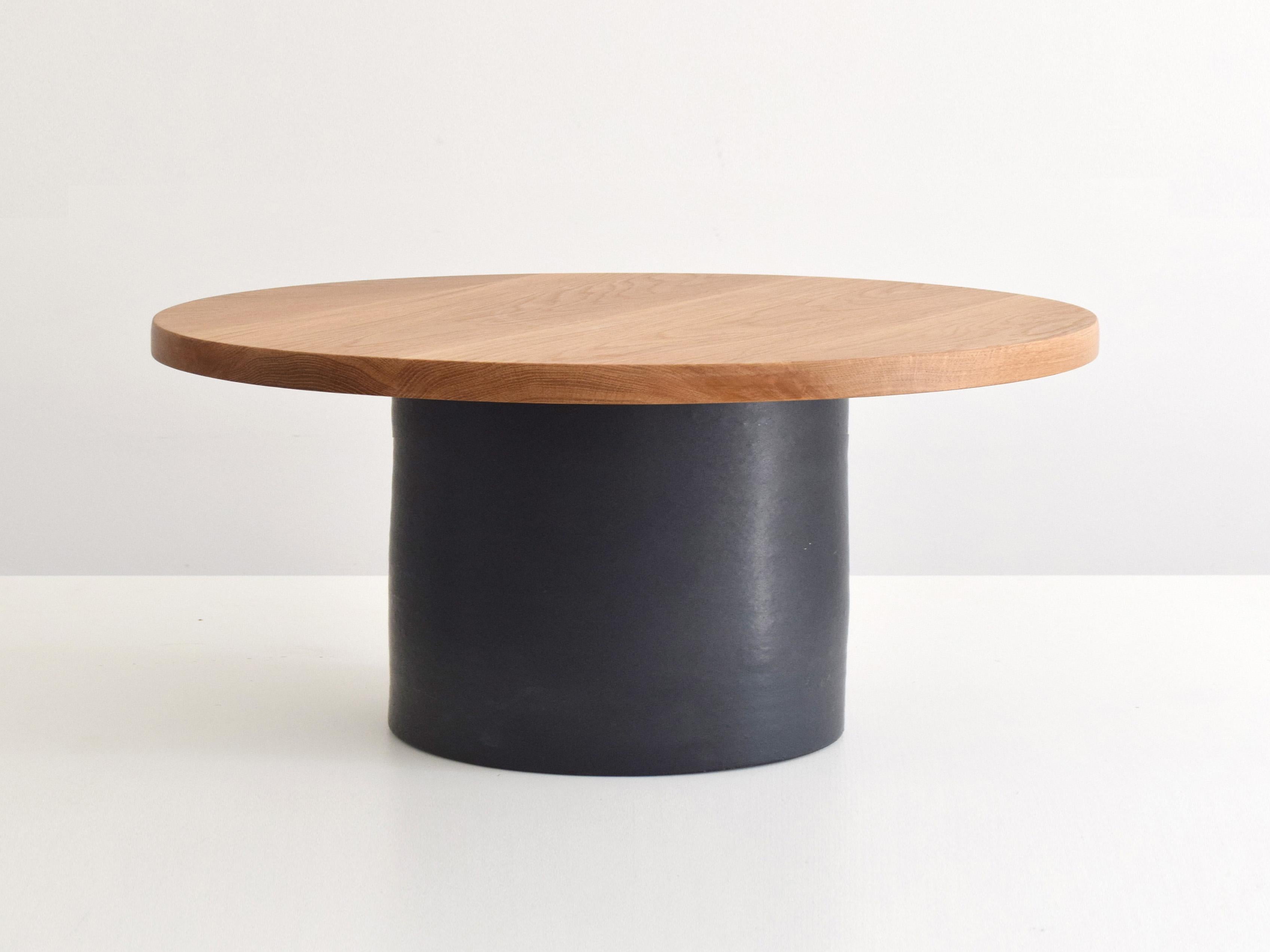 This coffee table pairs a bold ceramic pedestal base with a solid oak top, offering both presence and functionality. The 80 cm round wood top provides ample space while adding natural warmth and contrast to the design. A statement piece for living
