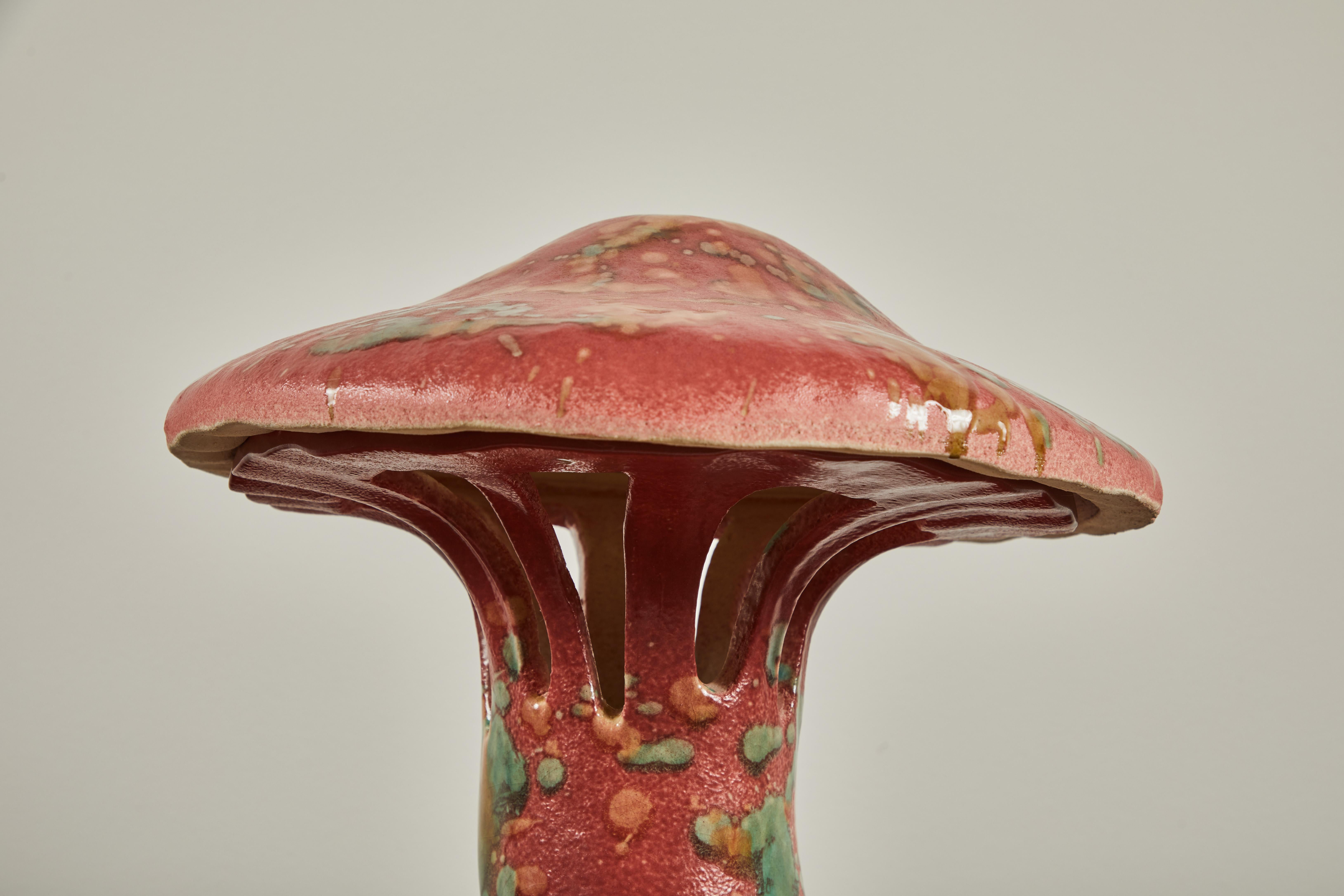 One of a kind and hand made, the ceramic Mushroom table lamp is earthy and unique. The lamp is wired with a red twist cloth cord. The lamp requires one bulb.

