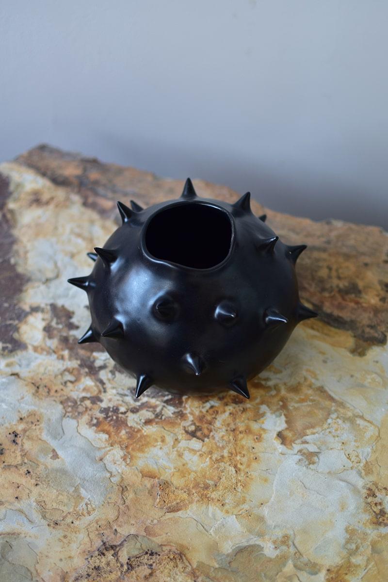 Schöne schwarze runde Vase mit Stacheln, perfekt für die Präsentation Ihrer geliebten Blumen. Diese runde Keramikvase bietet aus jedem Blickwinkel eine einzigartige Perspektive und lässt die Grenze zwischen Funktionalität und Ornament verschwimmen.