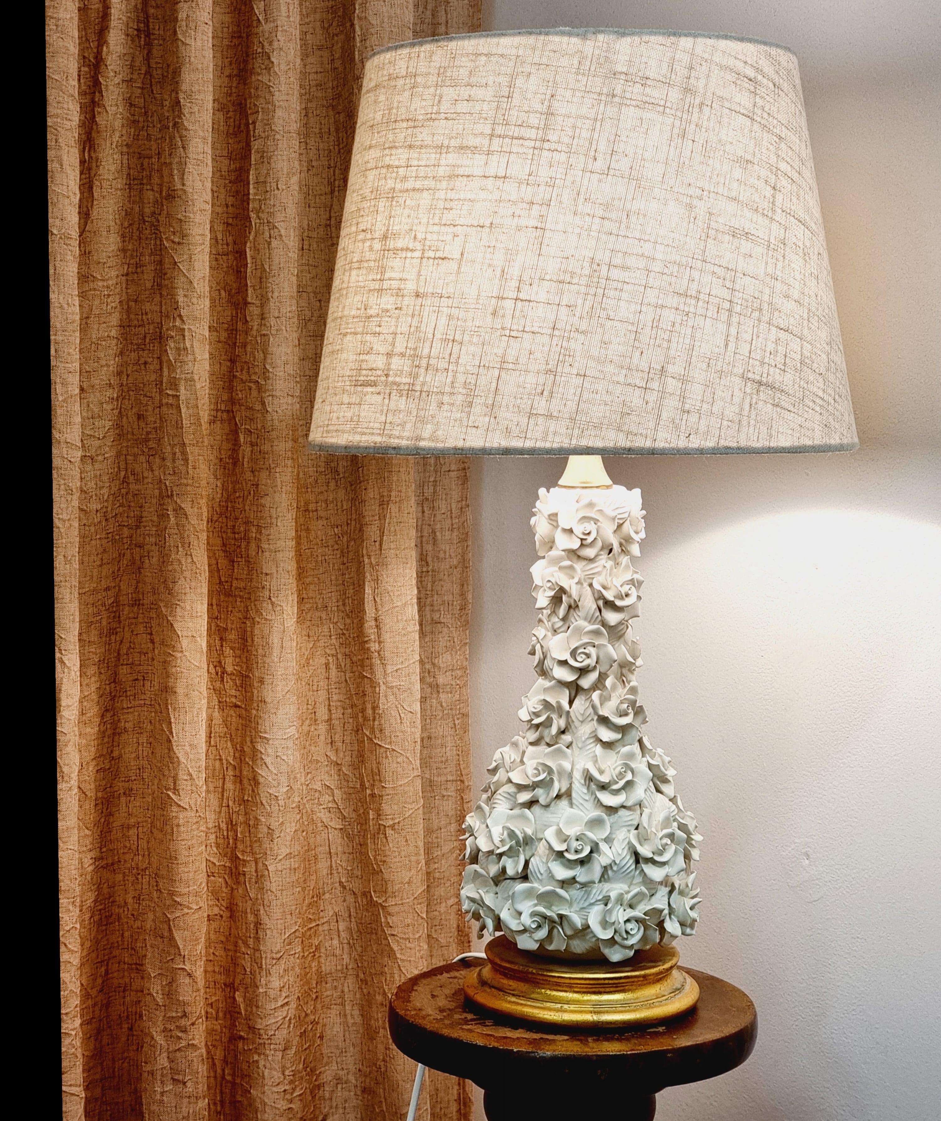 A decorative handmade ceramic table lamp with rose decor. Gold colored wooden base. Baluster shape and brass detail at the top. Beautiful and sculptural. 

In good condition, a few chips, normal signs of age and wear. 

   