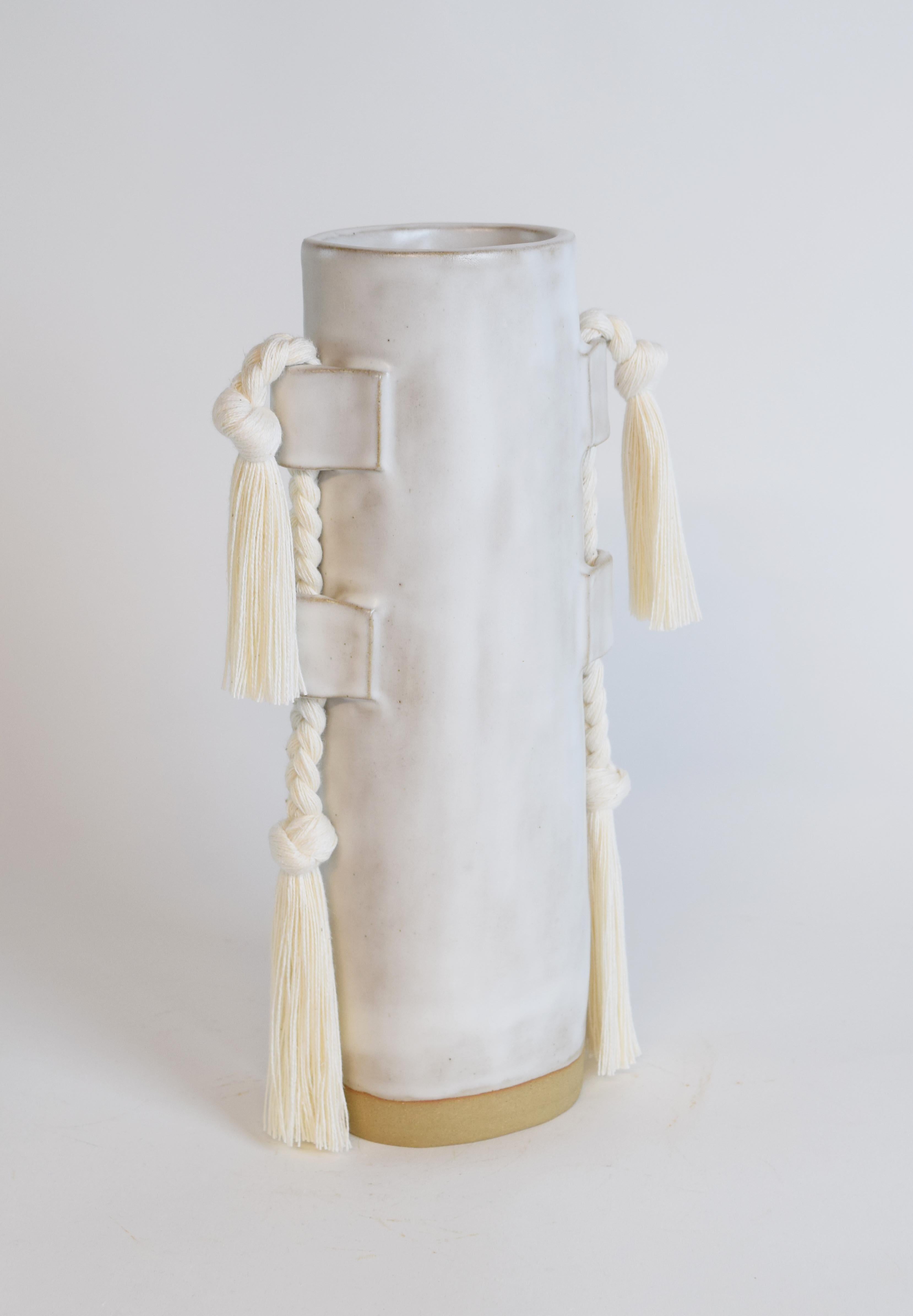 Vase #504 by Karen Gayle Tinney

A fan-favorite since its introduction in 2018, this versatile vase functions equally as a sculptural object and a vessel for flowers.

Hand formed stoneware with satin white White cotton braided details. Inside is