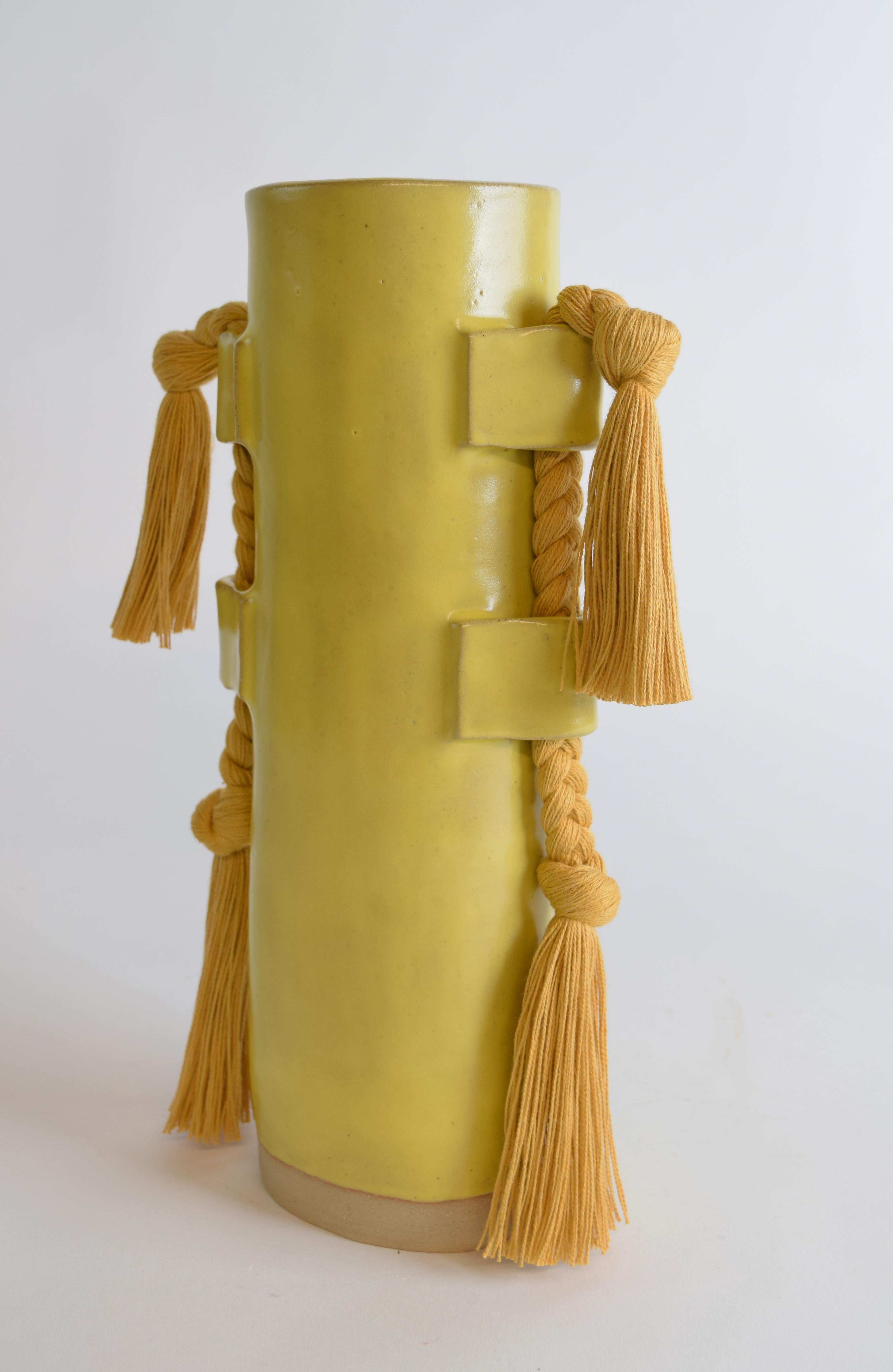 Vase #504 by Karen Gayle Tinney

A fan-favorite since its introduction in 2018, this versatile vase functions equally as a sculptural object and a vessel for flowers.

Hand formed stoneware with satin yellow glaze, marigold cotton braided details.