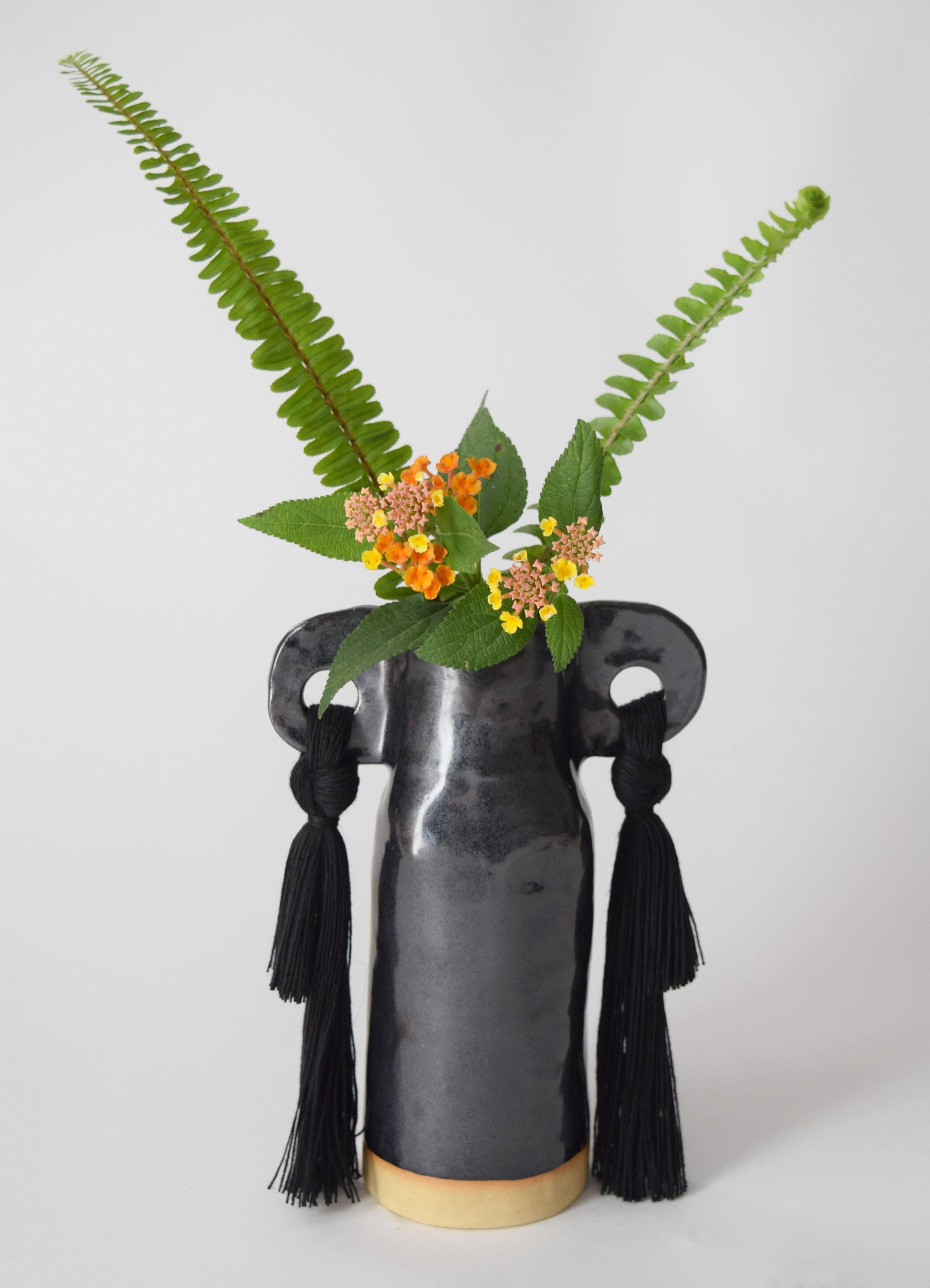 Vase #606 by Karen Gayle Tinney

A petite vase perfectly sized to stand alone in a small space or act as a companion to a larger piece. Each vase is formed by hand, making every piece unique.

Stoneware with black glaze. Black cotton fringe