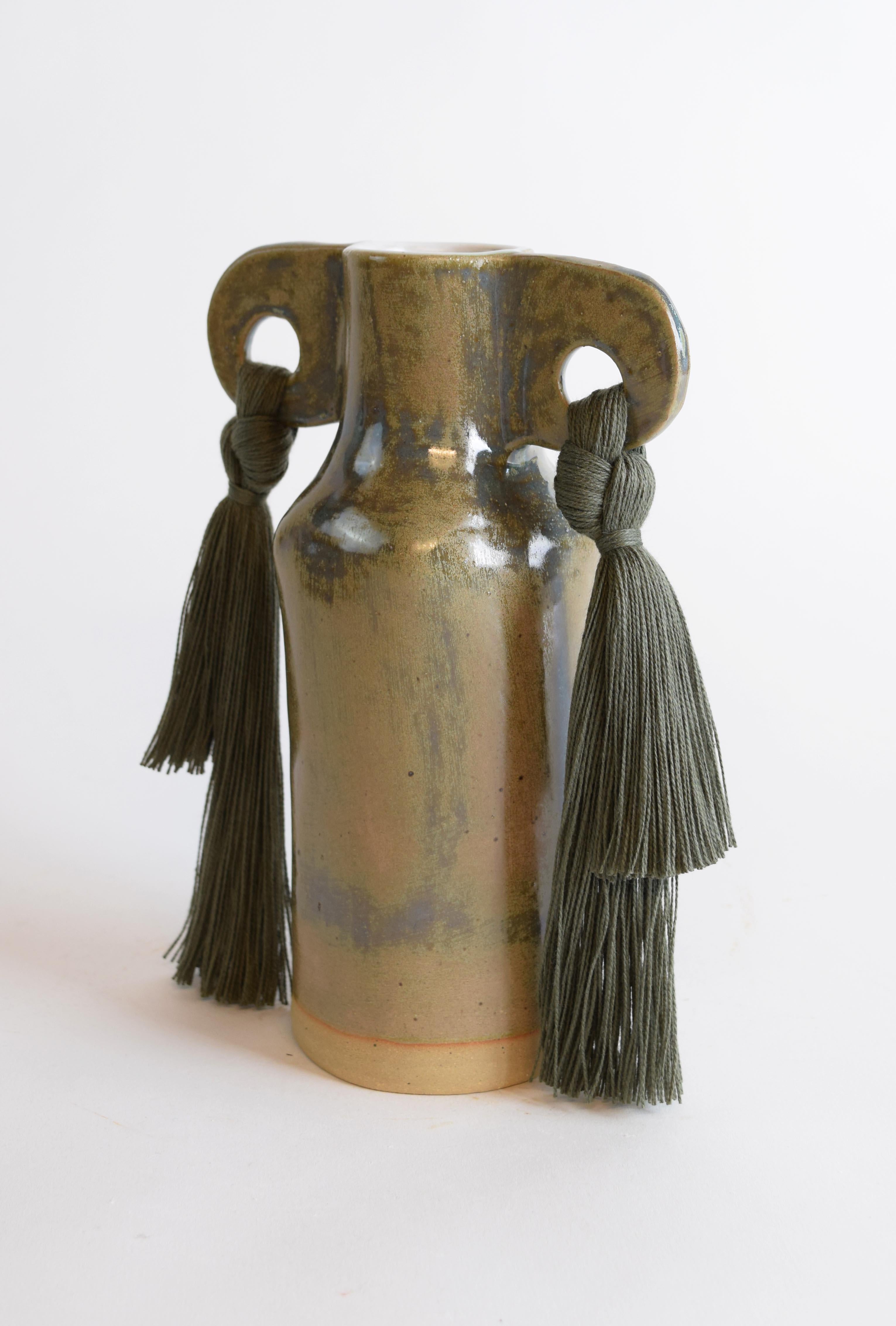 Vase #606 by Karen Gayle Tinney

A petite vase perfectly sized to stand alone in a small space or act as a companion to a larger piece. Each vase is formed by hand, making every piece unique.

Stoneware with olive glaze. Olive cotton fringe detail.