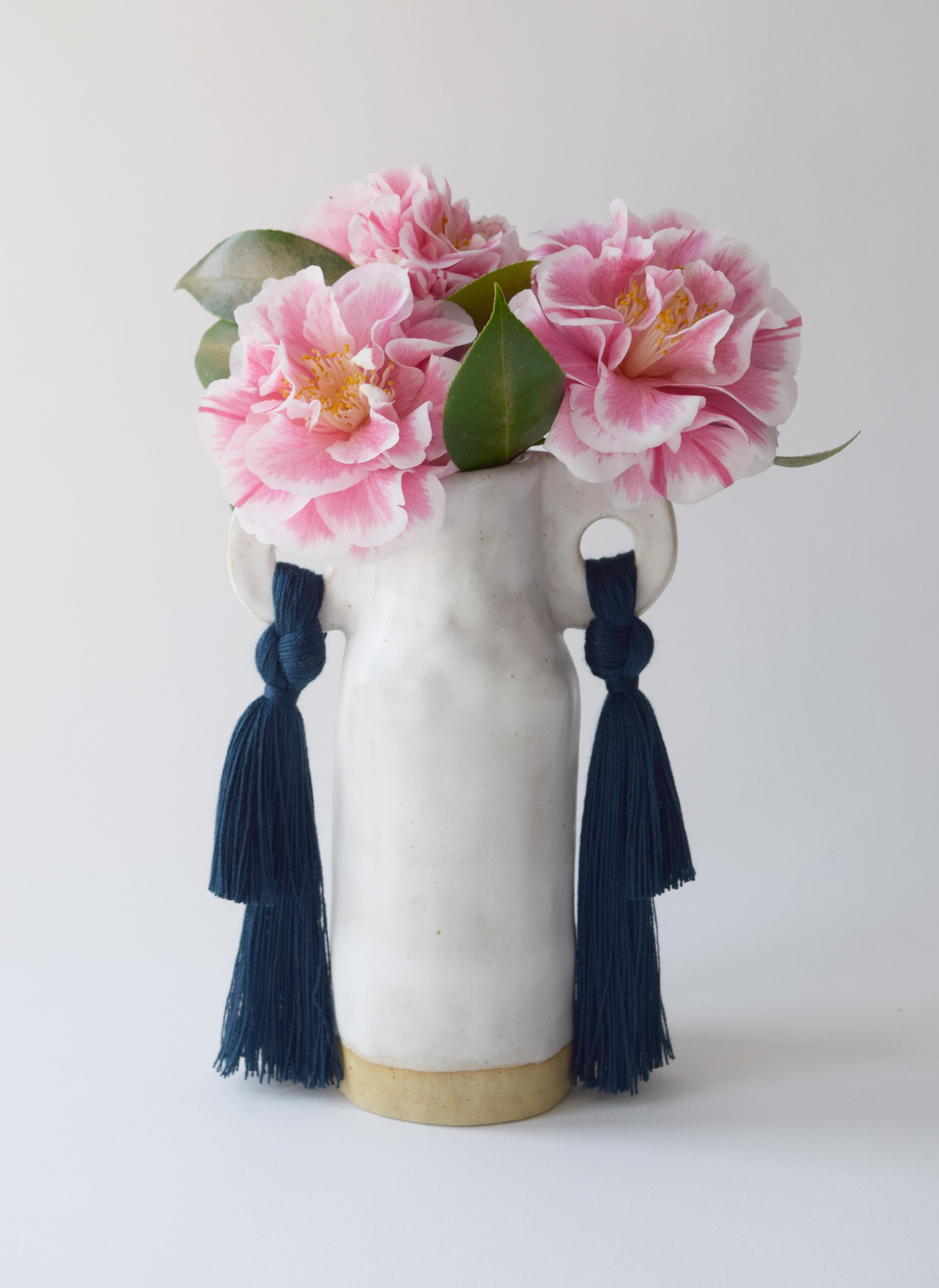 Vase #606 by Karen Gayle Tinney

A petite vase perfectly sized to stand alone in a small space or act as a companion to a larger piece. Each vase is formed by hand, making every piece unique.

Stoneware with satin white glaze. Navy tencel fringe