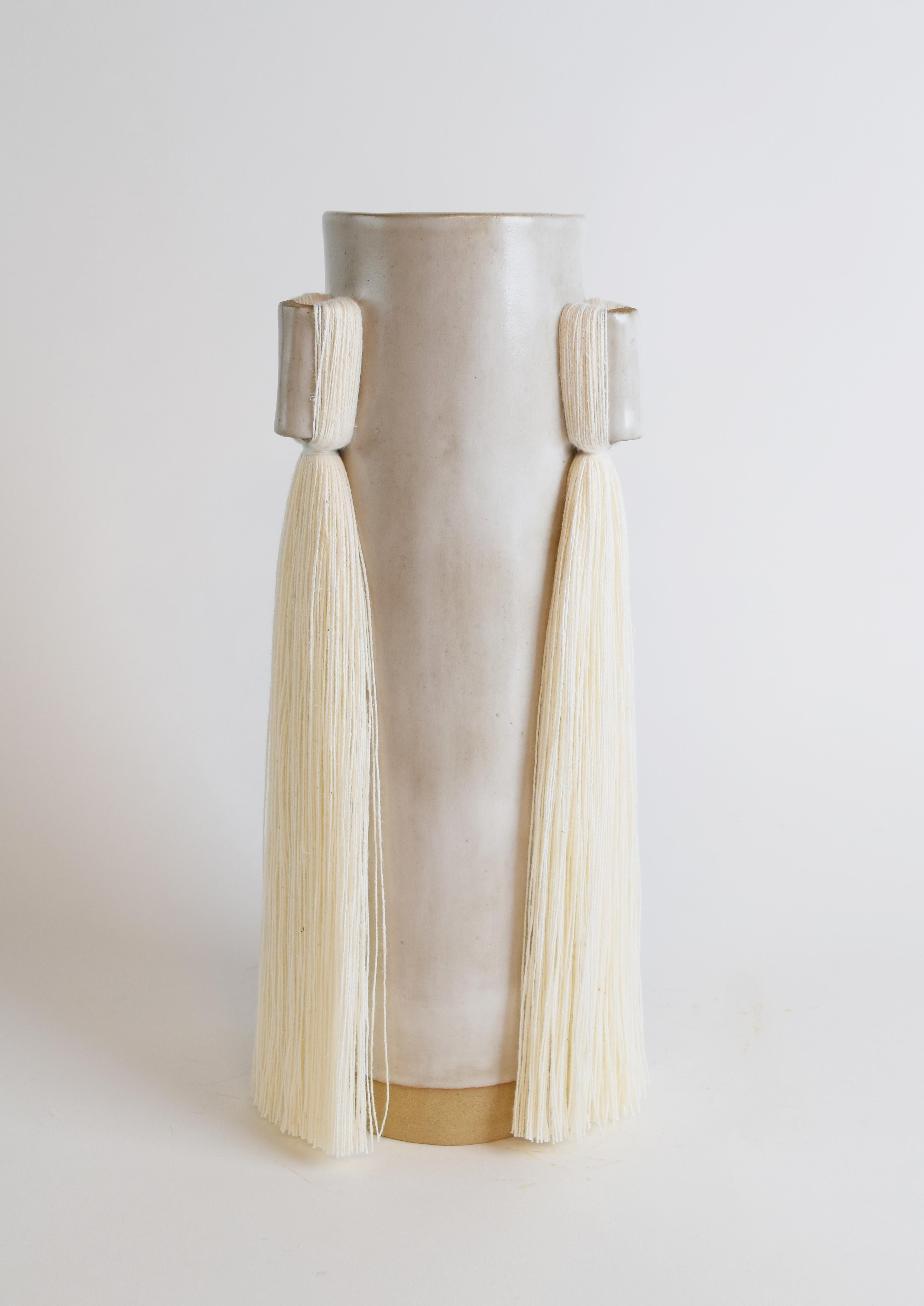 Vase #607 by Karen Gayle Tinney

Lengths of fringe adorn 3 sides of this vase which is sized generously to hold a large arrangement of flowers.

Hand formed stoneware with satin white glaze and white cotton fringe detail. Inside is glazed white,