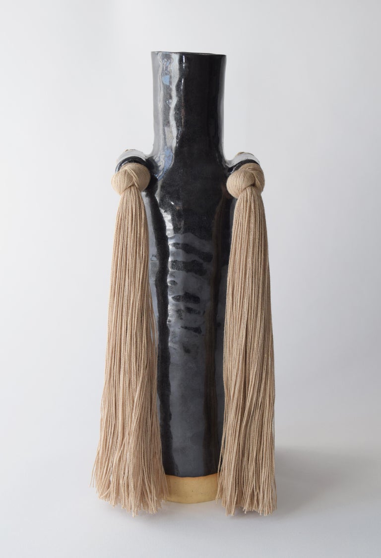 Vase #703 by Karen Gayle Tinney

This hand formed stoneware vase with black glaze and beige cotton detail applied to the outside is an update to a traditional bottle neck silhouette. Inside is glazed black and will hold water, please take care not