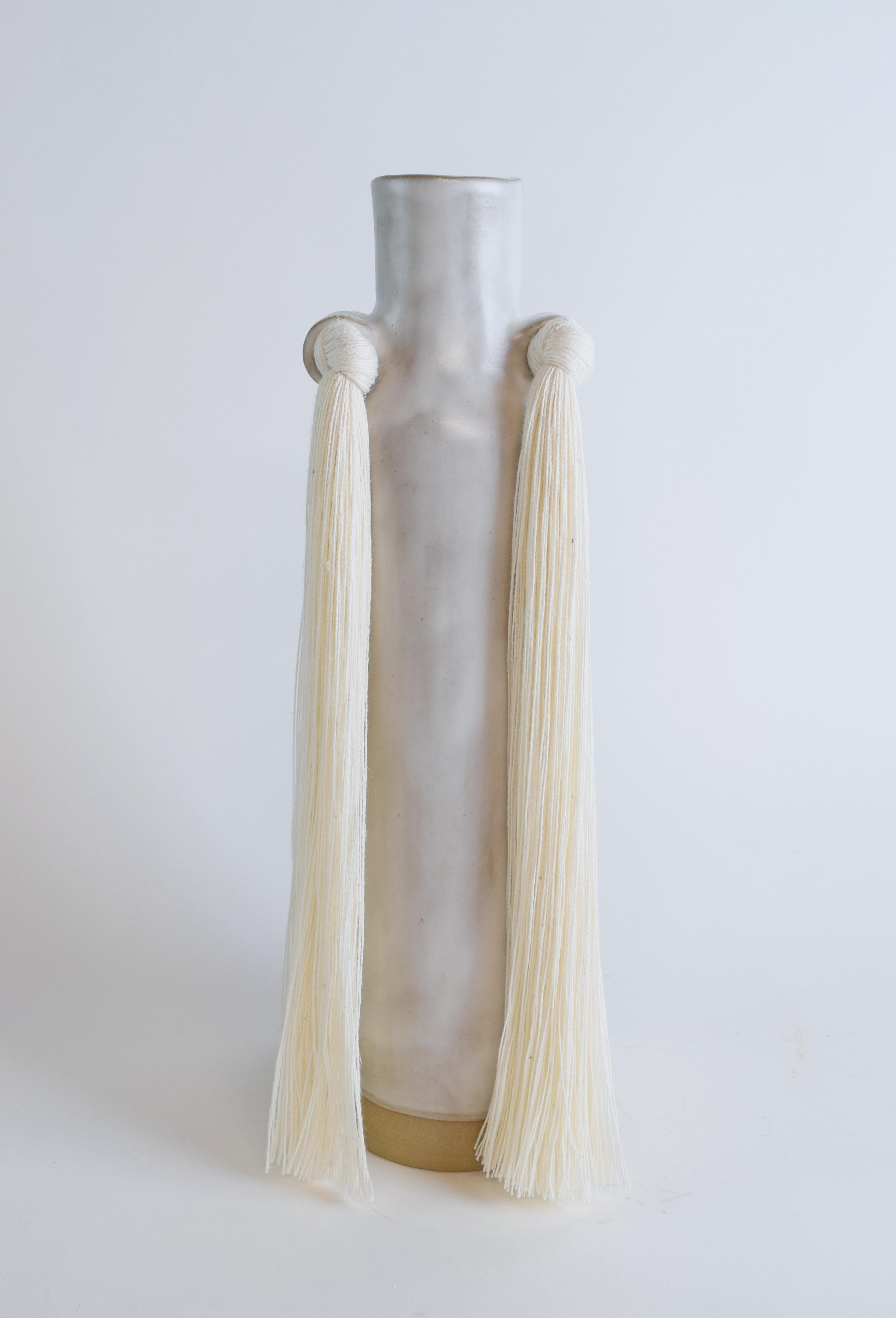 Vase #703 by Karen Gayle Tinney

Drawing on signature details from other Standard Collection pieces, this vase is an update to a traditional bottle neck silhouette. 

Hand formed beige stoneware with satin white glaze. white cotton fringe detail.