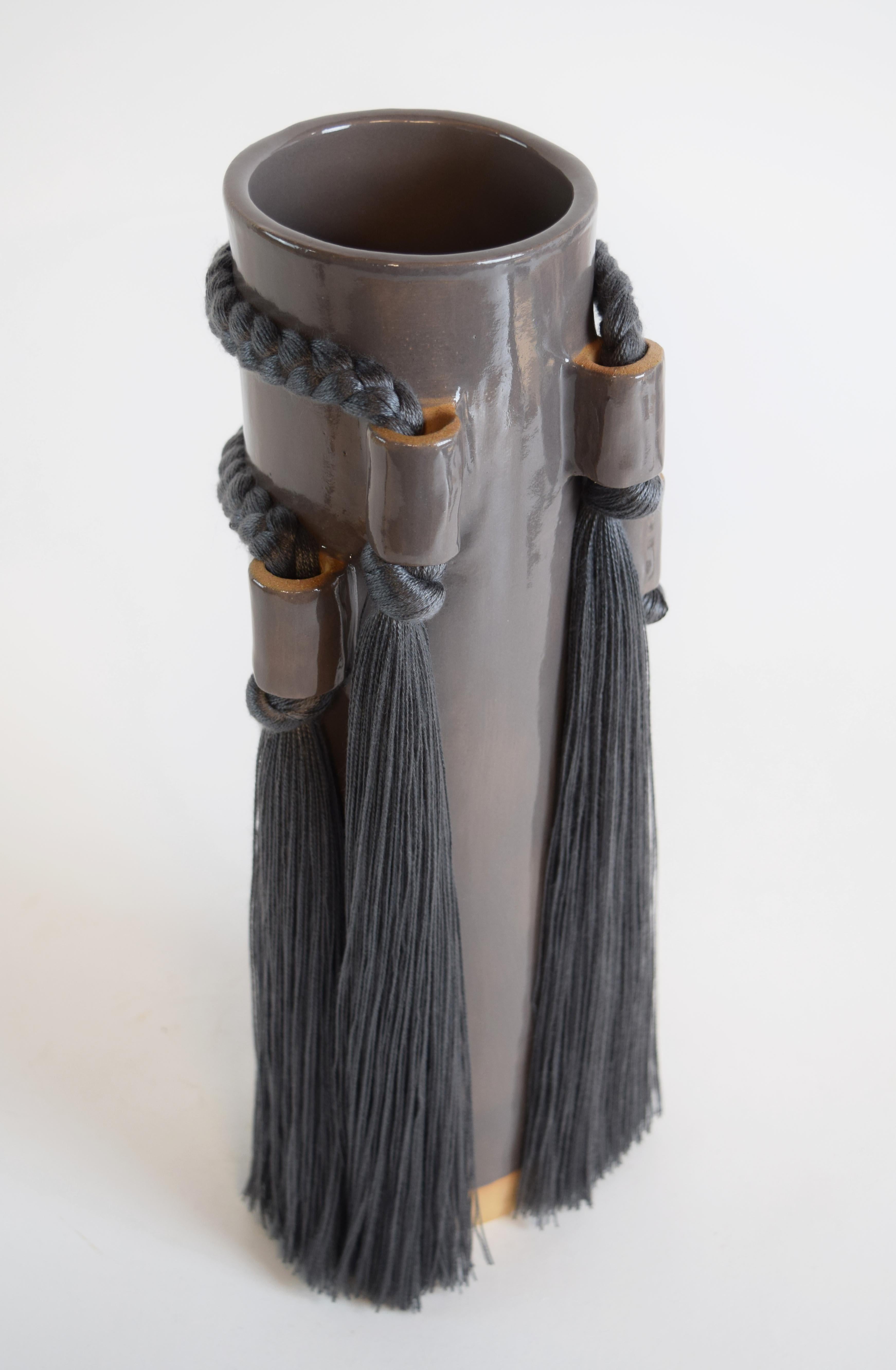 Vase #703 by Karen Gayle Tinney

Featuring fringe and braided details from all views, this vase is sized to hold a large arrangement of flowers or to stand alone as a sculptural piece.

Hand formed stoneware with charcoal glaze. Charcoal tencel